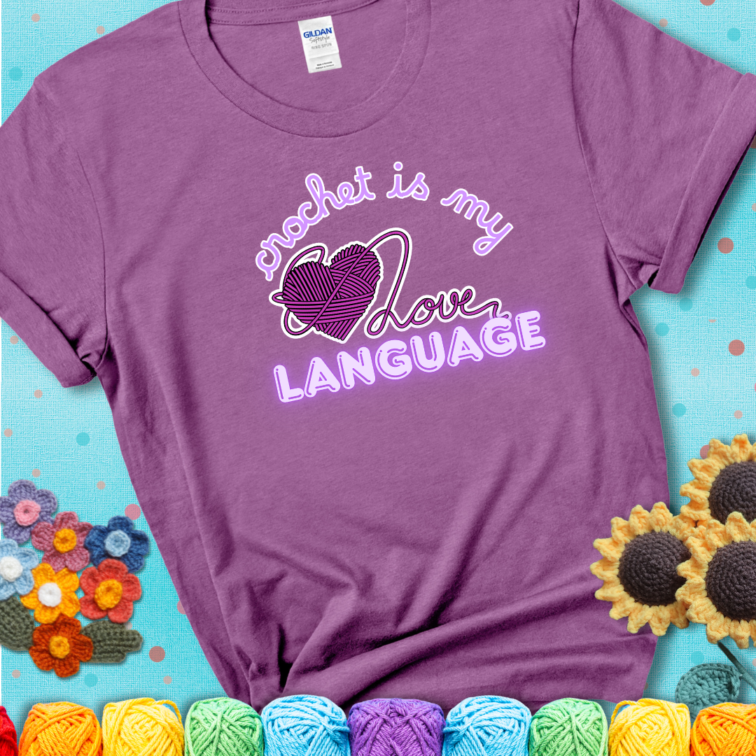 Say it with stitches Design reads 'Crochet Is My Love Language', perfect crochet gift for yarn lovers; showing a lavender tee with a teal sunflower background