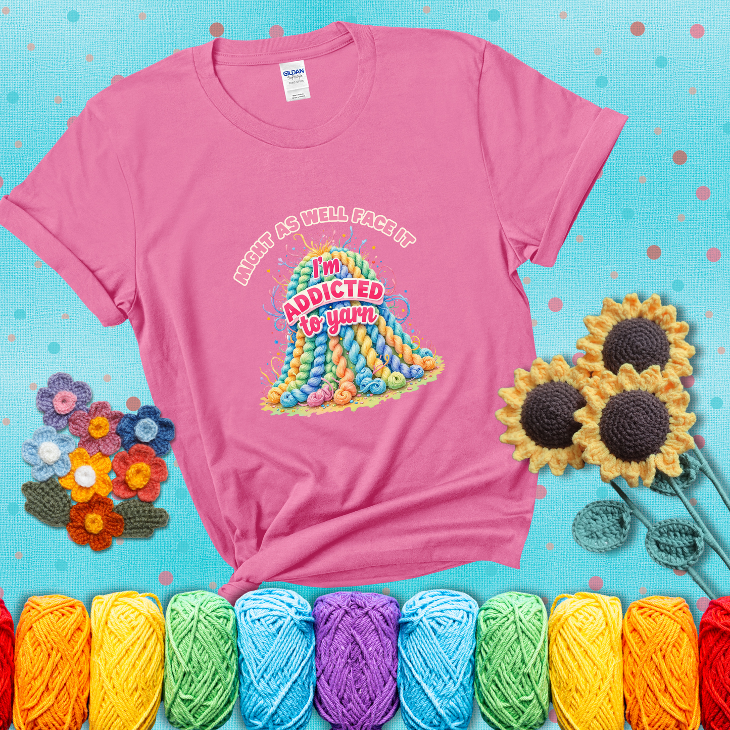 Colorful mountain of pastel yarn hanks with the phrase “Might as well face it, I’m addicted to yarn” in playful pink and red lettering showing a pink tee with a teal sunflower background