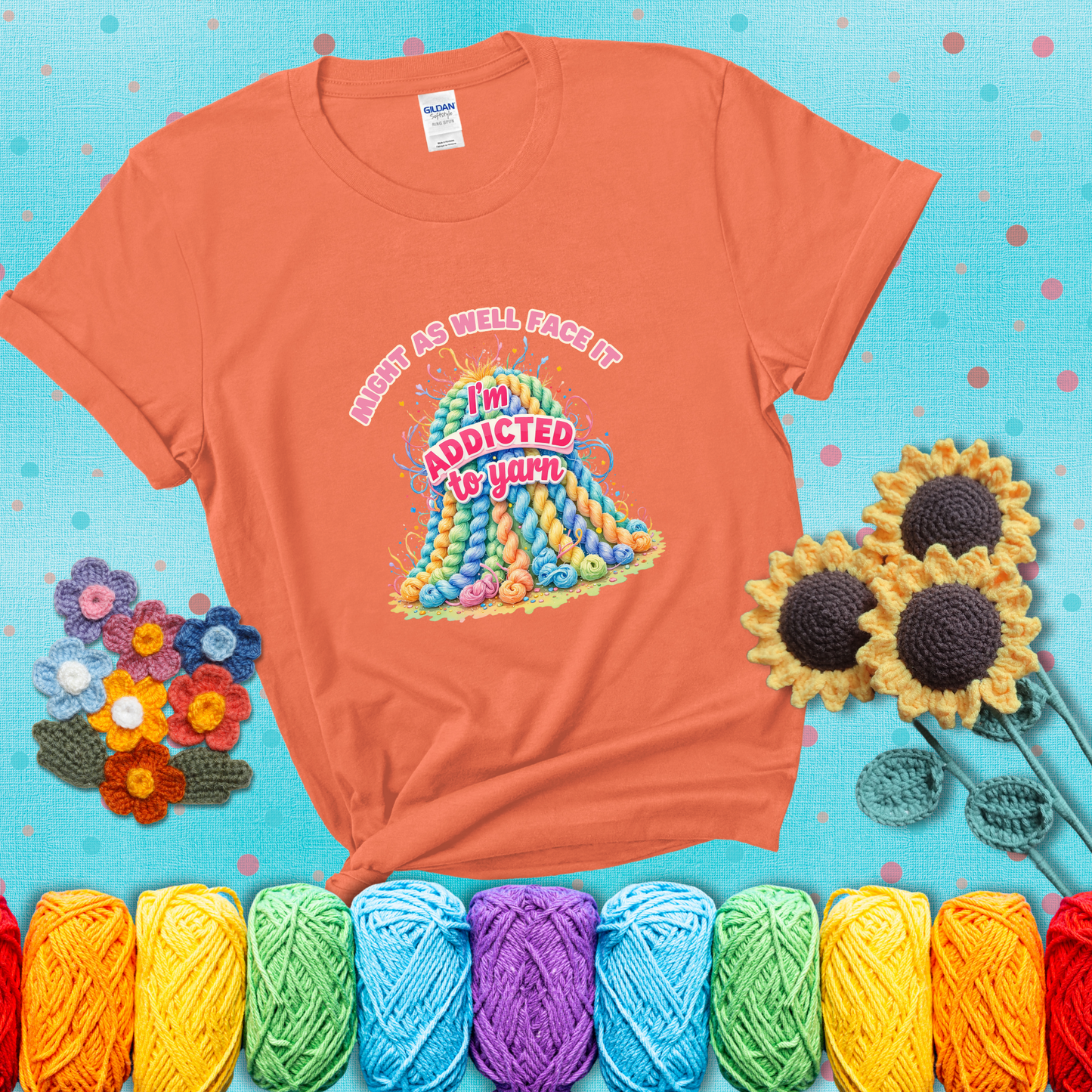 Colorful mountain of pastel yarn hanks with the phrase “Might as well face it, I’m addicted to yarn” in playful pink and red lettering showing a light orange tee with a teal sunflower background