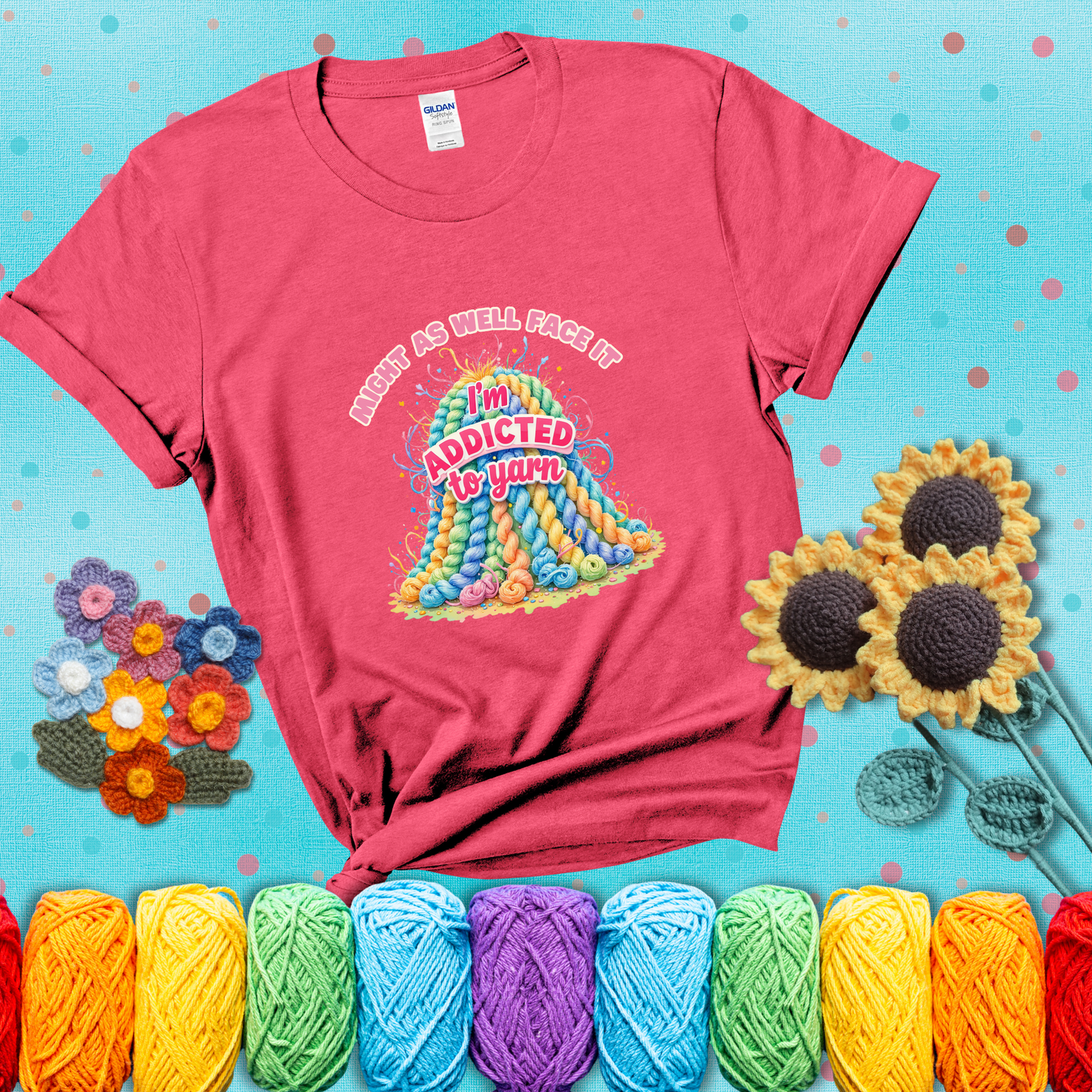 Colorful mountain of pastel yarn hanks with the phrase “Might as well face it, I’m addicted to yarn” in playful pink and red lettering showing a light red tee with a teal sunflower background