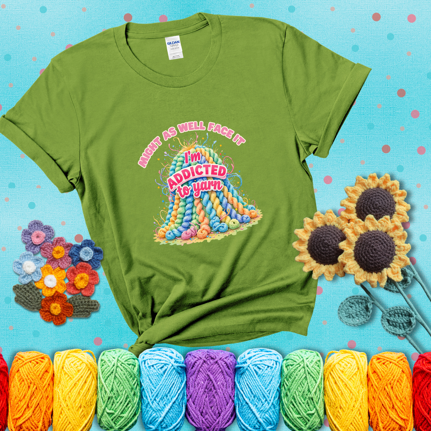 Colorful mountain of pastel yarn hanks with the phrase “Might as well face it, I’m addicted to yarn” in playful pink and red lettering showing a bright green tee with a teal sunflower background