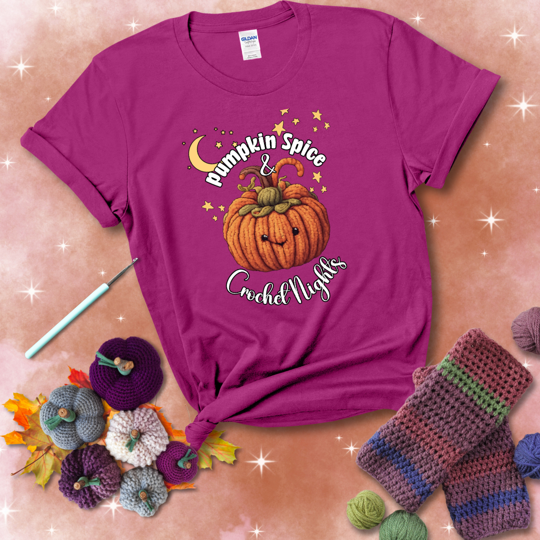 Smiling pumpkin crocheted with yarn texture, surrounded by stars and a crescent moon. Text reads “Pumpkin Spice & Crochet Nights” showing a magenta tee with a festive Fall background