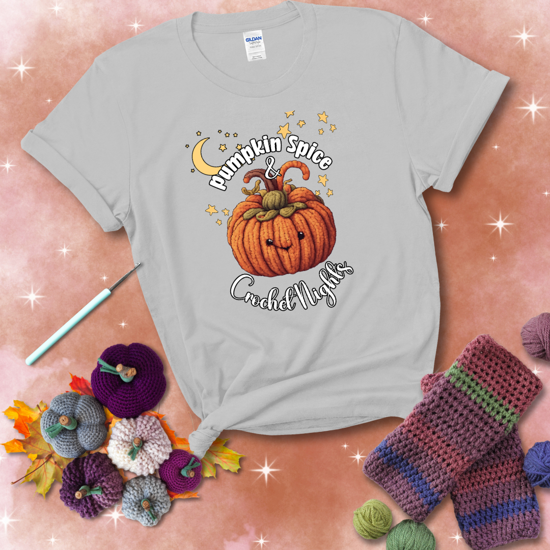 Smiling pumpkin crocheted with yarn texture, surrounded by stars and a crescent moon. Text reads “Pumpkin Spice & Crochet Nights” showing a light grey tee with a festive Fall background