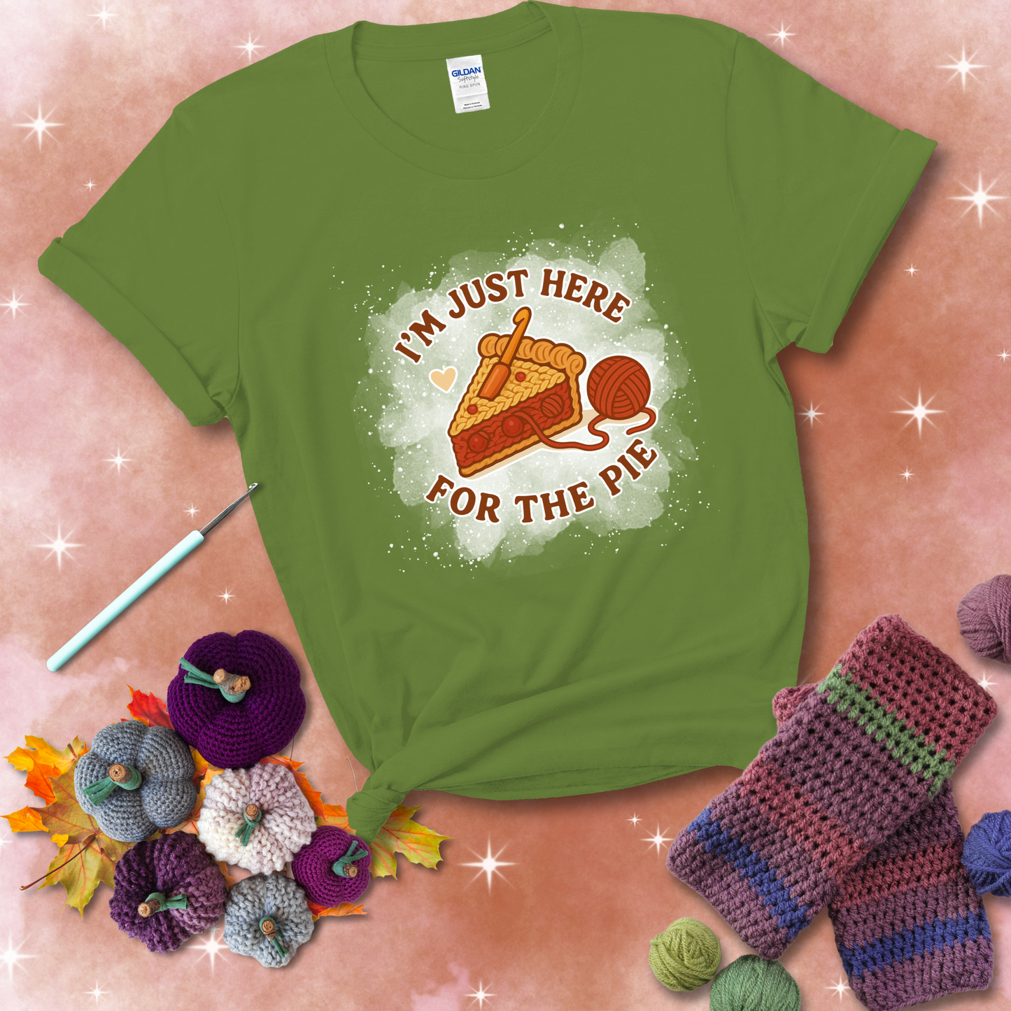 A slice of cherry pie with a crochet hook tucked in the filling and yarn trailing out, blending baking with crochet fun, showing a bright green tee with a festive Fall background