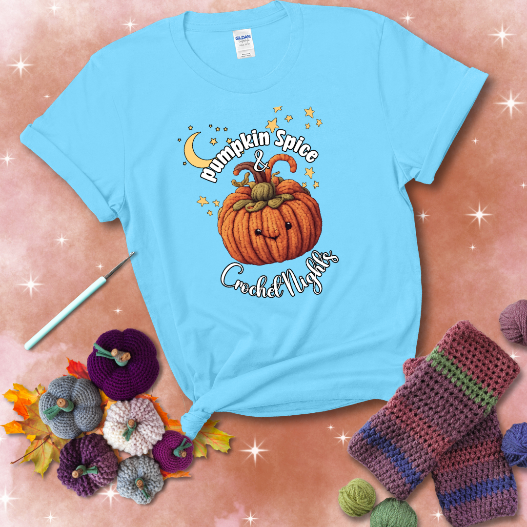 Smiling pumpkin crocheted with yarn texture, surrounded by stars and a crescent moon. Text reads “Pumpkin Spice & Crochet Nights” showing a light blue tee with a festive Fall background