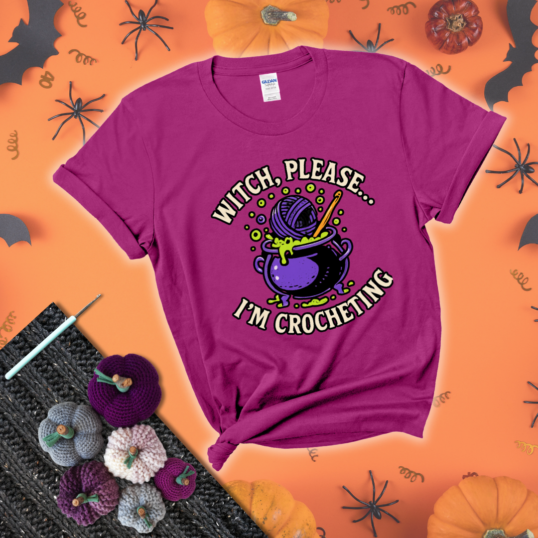 Put a spell on your stash Design reads 'Witch, Please… I’m Crocheting,' perfect crochet gift for yarn lovers showing a magenta tee with a festive Halloween background