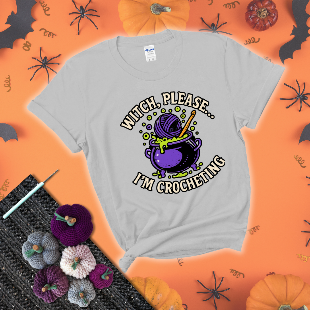 Put a spell on your stash Design reads 'Witch, Please… I’m Crocheting,' perfect crochet gift for yarn lovers showing a light grey tee with a festive Halloween background