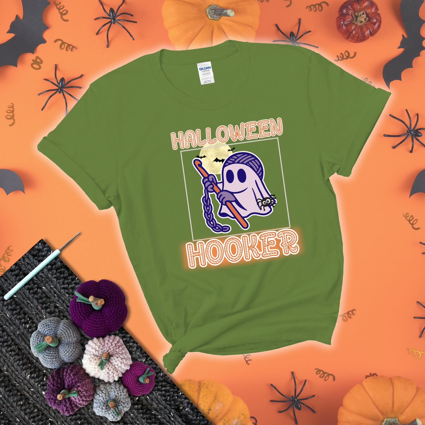 Cartoon ghost crocheter with a yarn ball head, crochet hook, bats, and text “Halloween Hooker,” a fun spooky tee for yarn lovers showing a bright green tee with a festive Halloween background