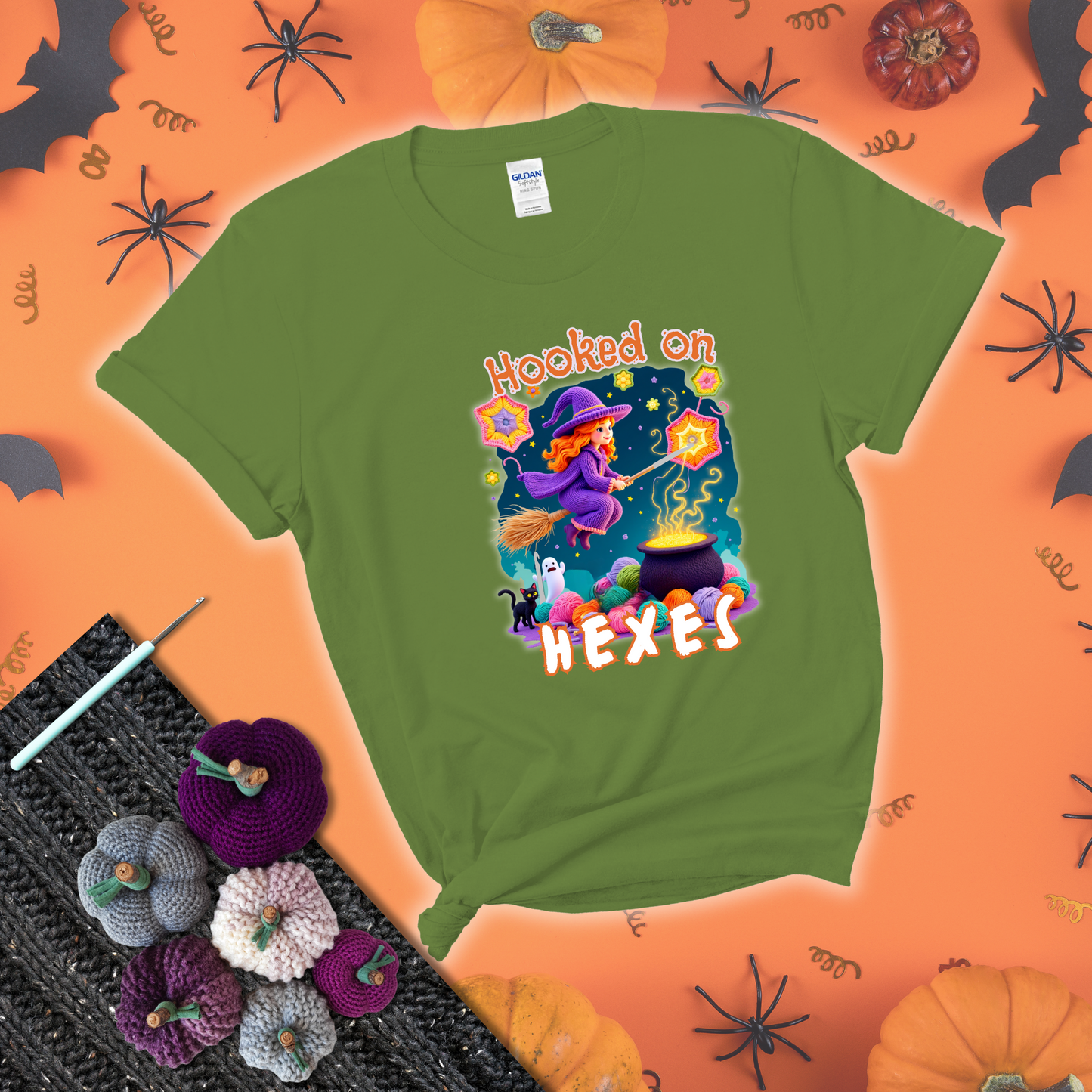 Witchy vibe with stars, hexagons, and a crochet hook. Text reads: “Hooked on Hexes.” A mystical and moody tee for fans of spooky stitches showing a bright green tee with a festive Halloween background