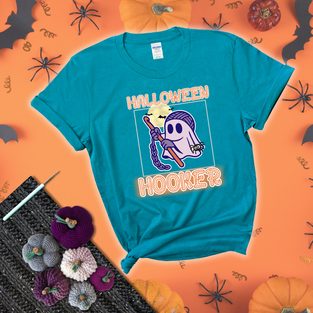Cartoon ghost crocheter with a yarn ball head, crochet hook, bats, and text “Halloween Hooker,” a fun spooky tee for yarn lovers showing a blue-green tee with a festive Halloween background