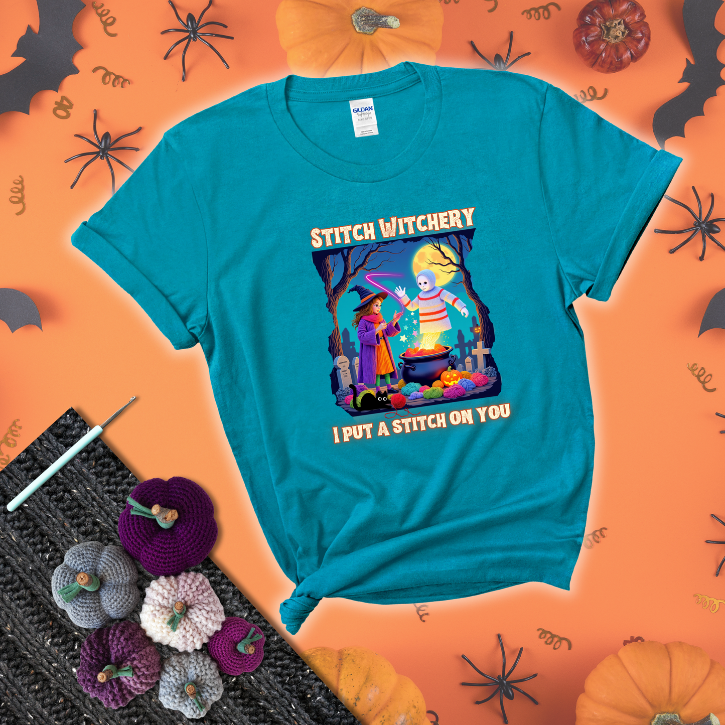 A Halloween scene with a young witch casting a yarn spell from a cauldron onto a floating crochet-ghost figure, under the phrase “I Put a Stitch on You” showing a blue-green tee with a festive Halloween background