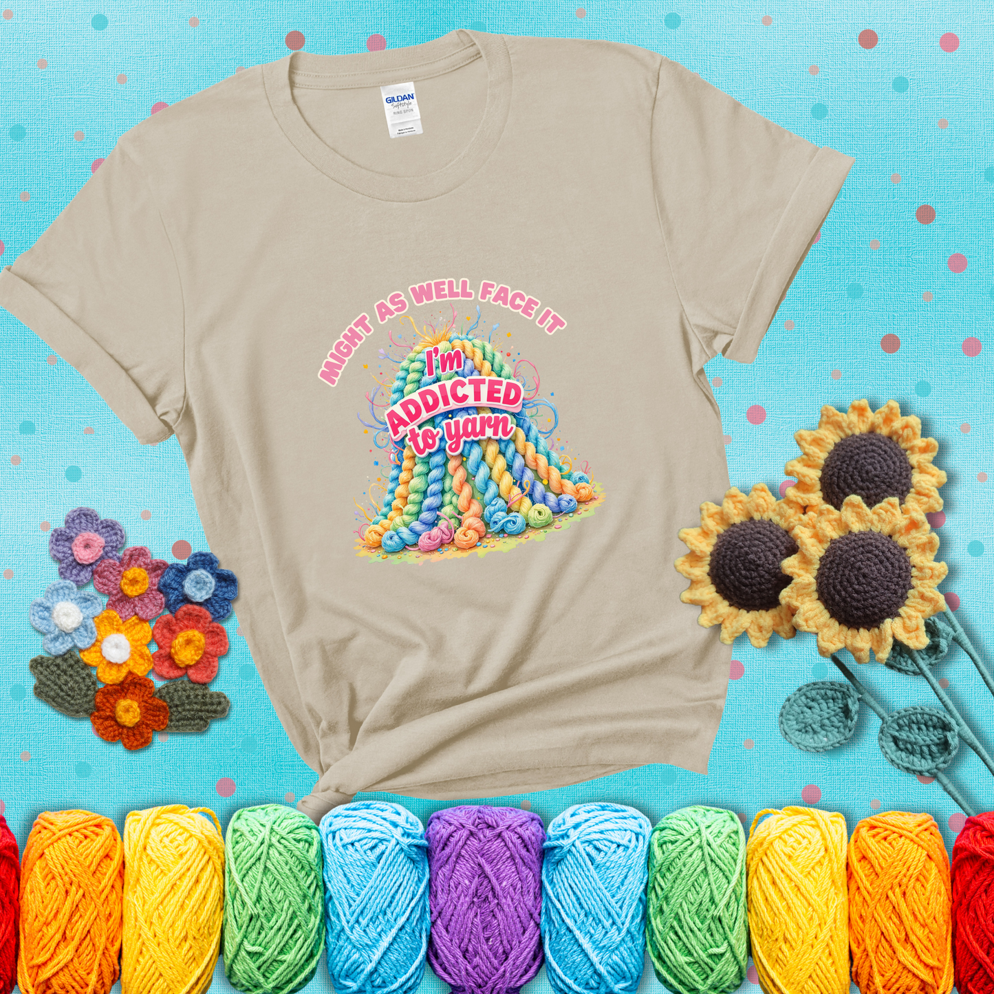 Colorful mountain of pastel yarn hanks with the phrase “Might as well face it, I’m addicted to yarn” in playful pink and red lettering showing a beige tee with a teal sunflower background