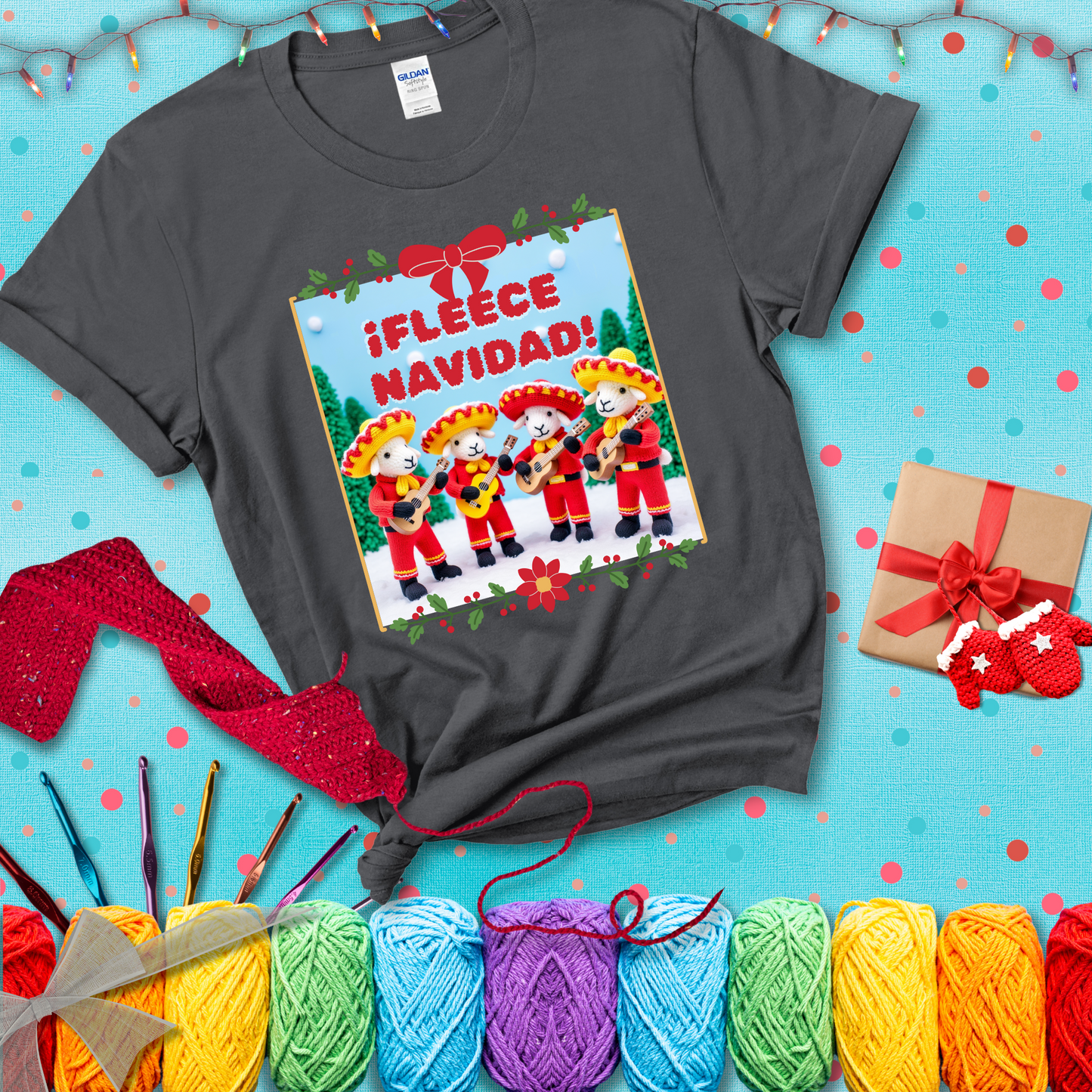 Four crocheted sheep dressed in red mariachi outfits with guitars, standing in a snowy scene under the phrase “¡Fleece Navidad!” showing a dark grey tee with a festive Christmas background