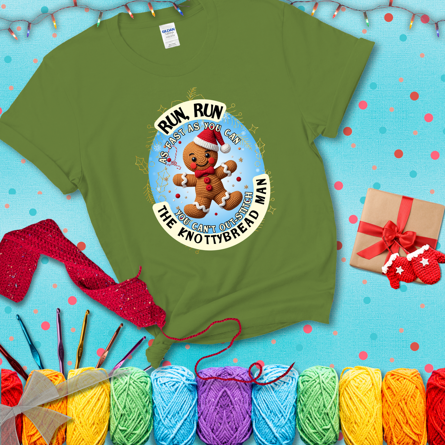 Cute crocheted gingerbread man in Santa hat with playful text: “Run, Run As Fast As You Can, You Can’t Out-Stitch the Knottybread Man.” A festive crochet pun shirt, showing a bright green tee with a festive Christmas background