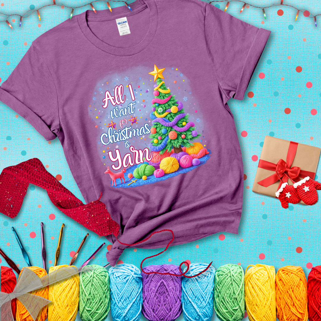 Bright Christmas tree decorated with yarn garlands, balls of yarn underneath, and the text “All I Want for Christmas is Yarn” in festive fonts, showing a light purple tee with a festive Christmas background