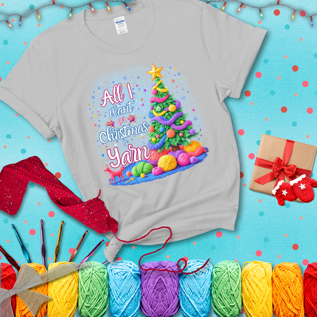 Bright Christmas tree decorated with yarn garlands, balls of yarn underneath, and the text “All I Want for Christmas is Yarn” in festive fonts, showing a light grey tee with a festive Christmas background