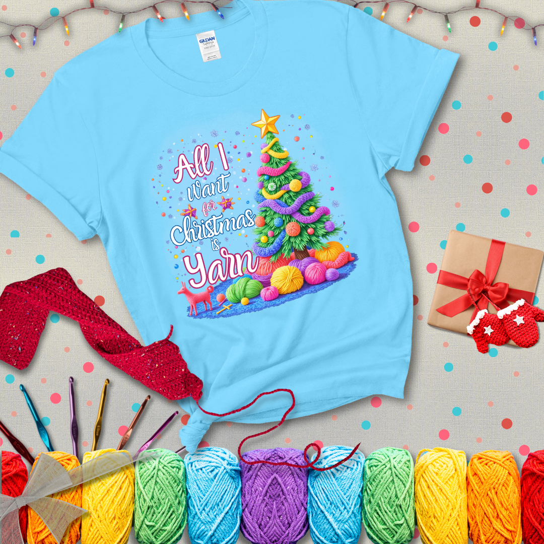 Bright Christmas tree decorated with yarn garlands, balls of yarn underneath, and the text “All I Want for Christmas is Yarn” in festive fonts, showing a light blue tee with a festive Christmas background