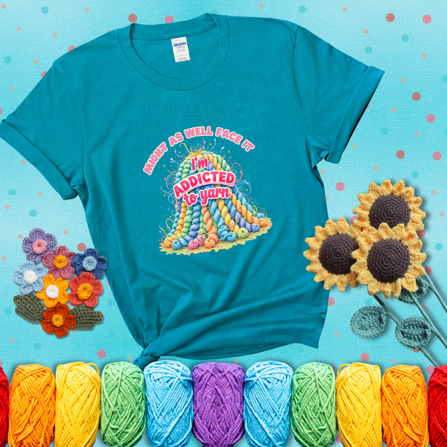 Colorful mountain of pastel yarn hanks with the phrase “Might as well face it, I’m addicted to yarn” in playful pink and red lettering showing a blue-green tee with a teal sunflower background