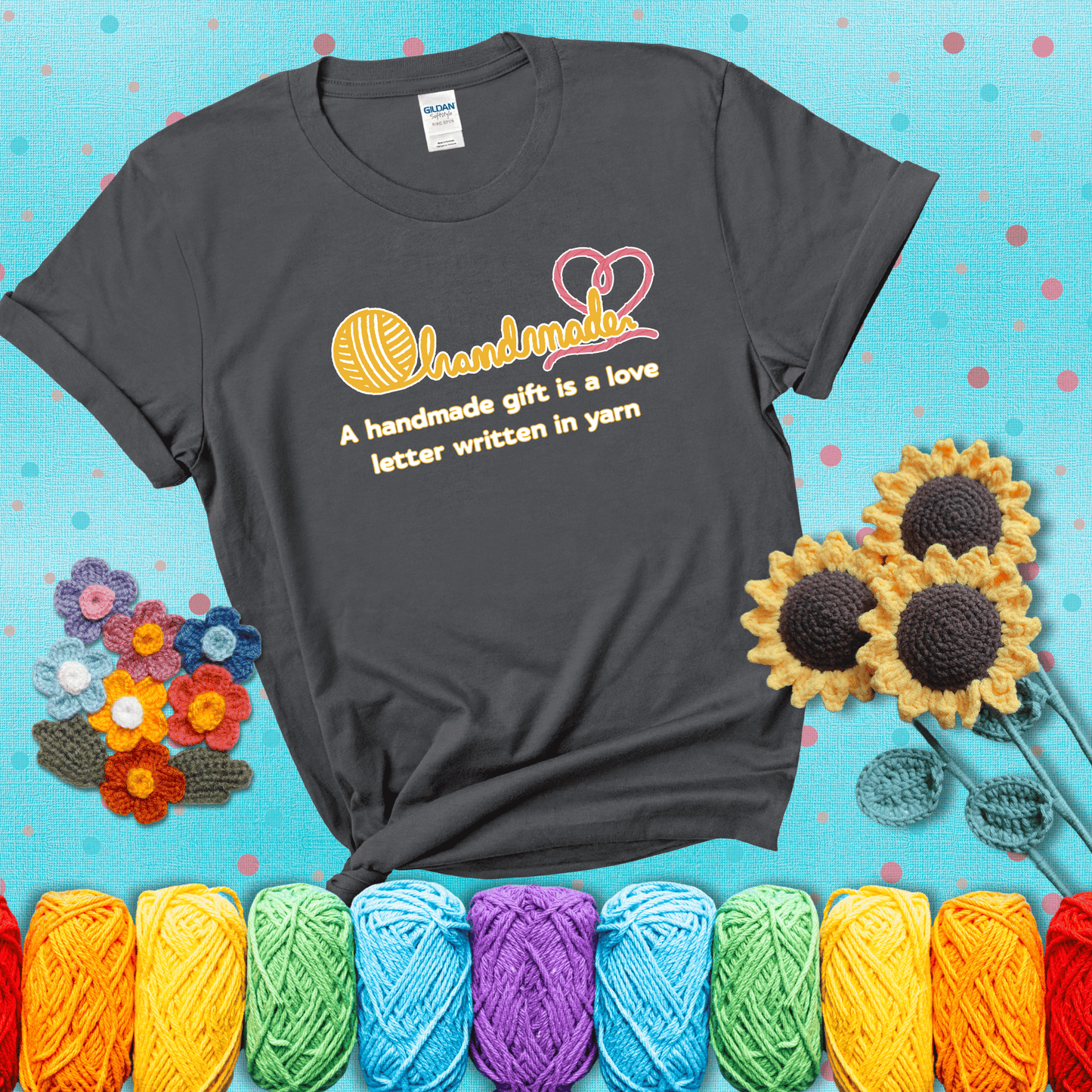 Soft script-style design with heart detail. Text reads: “A Handmade Gift Is a Love Letter Written in Yarn.” A sweet and sentimental shirt for crocheters who craft from the heart, showing a dark grey tee with a teal sunflower background