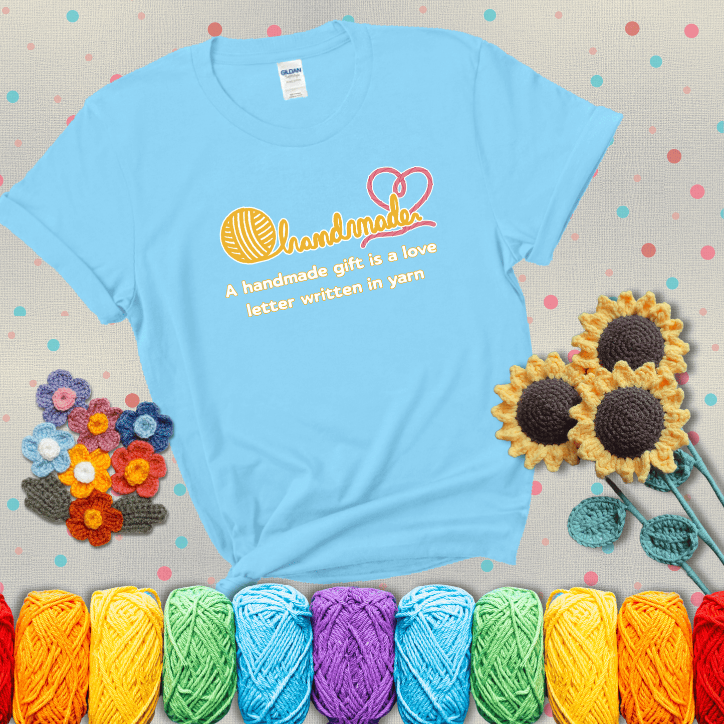 Soft script-style design with heart detail. Text reads: “A Handmade Gift Is a Love Letter Written in Yarn.” A sweet and sentimental shirt for crocheters who craft from the heart, showing a light blue tee with grey sunflower background