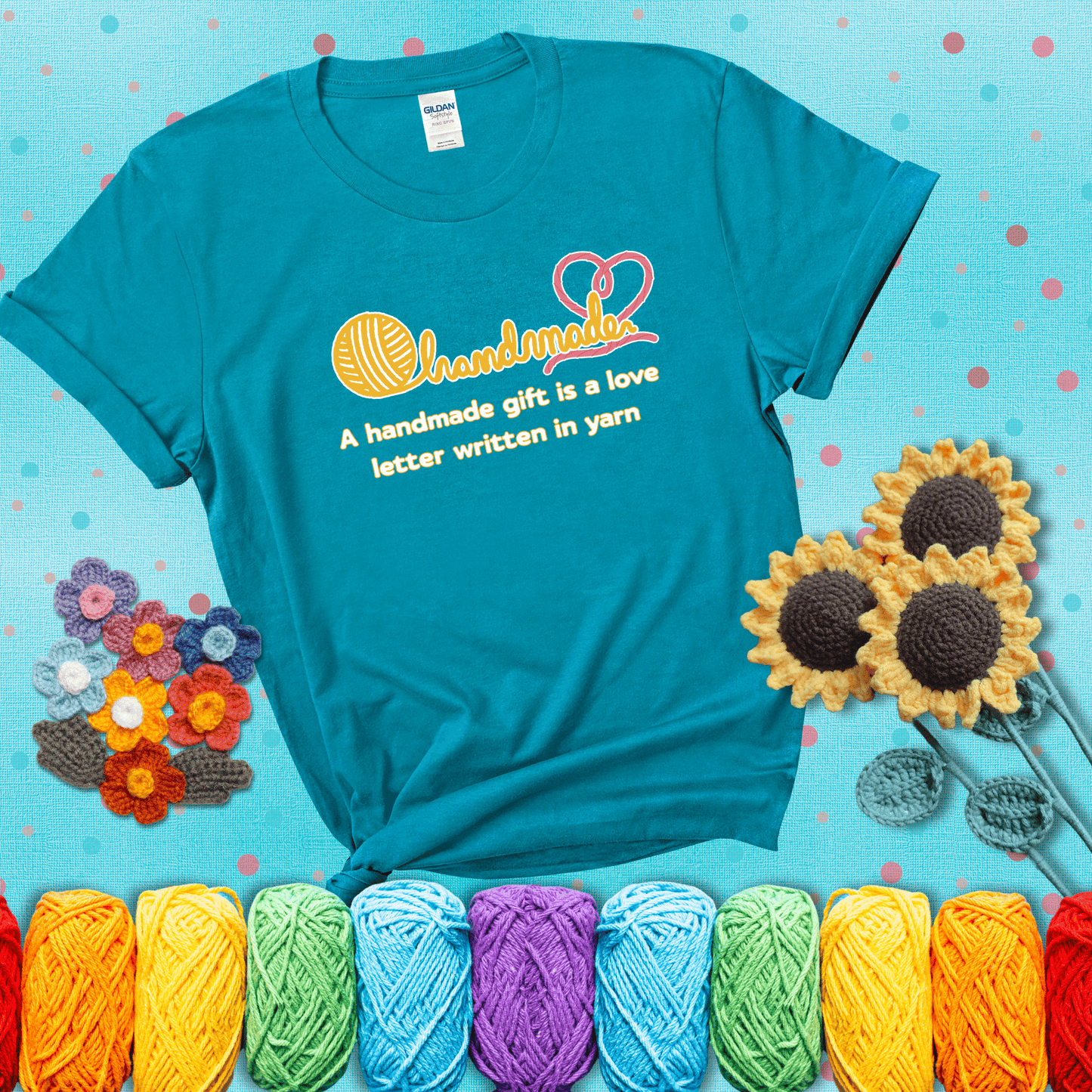Soft script-style design with heart detail. Text reads: “A Handmade Gift Is a Love Letter Written in Yarn.” A sweet and sentimental shirt for crocheters who craft from the heart, showing a blue-green tee with a teal sunflower background