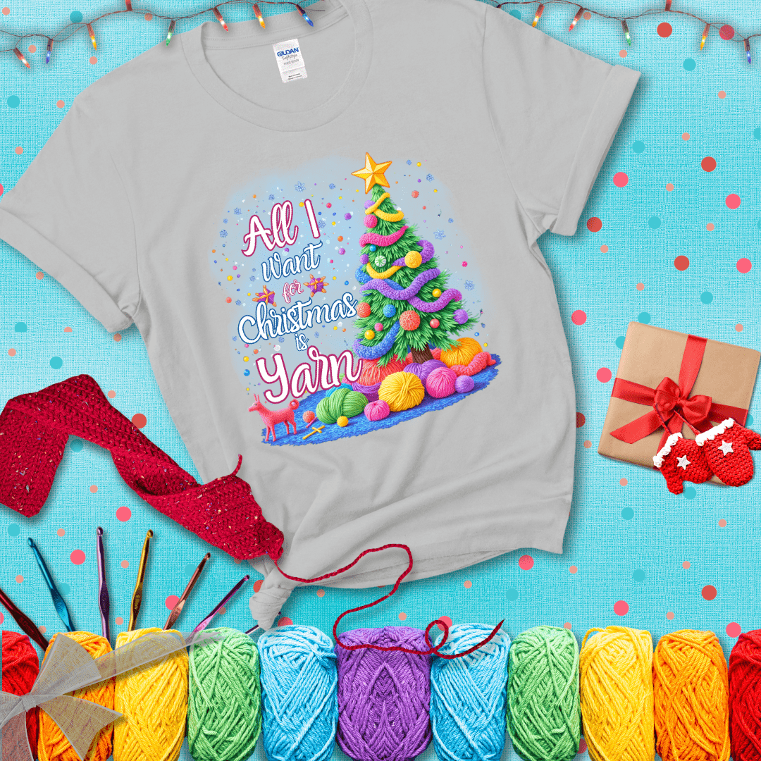 Bright Christmas tree decorated with yarn garlands, balls of yarn underneath, and the text “All I Want for Christmas is Yarn” in festive fonts, showing a light grey tee with a festive Christmas background