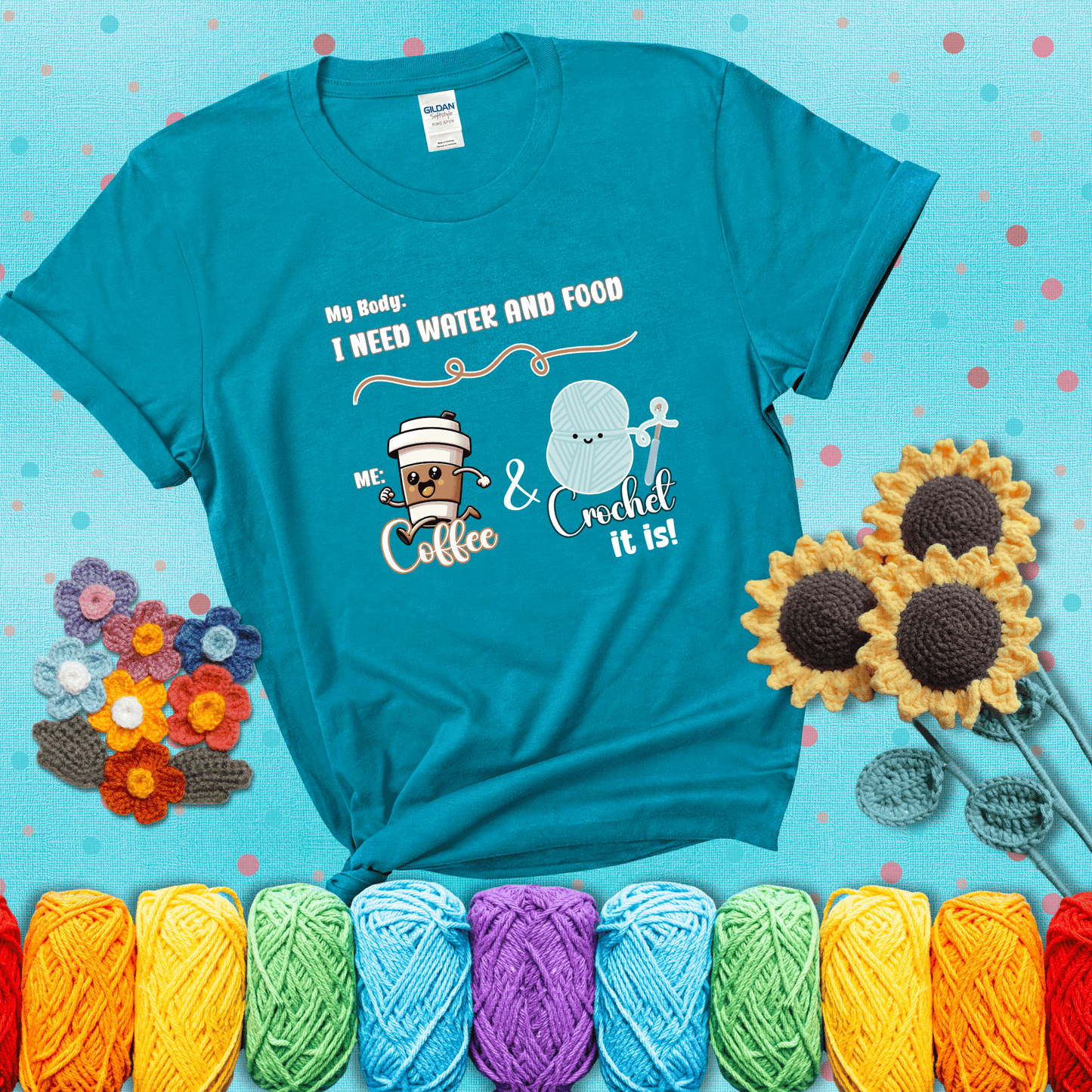Design reads “My body: I need water and food. Me: Coffee & Crochet it is,” with a smiling coffee cup and yarn ball characters showing a blue-green tee with a teal sunflower background