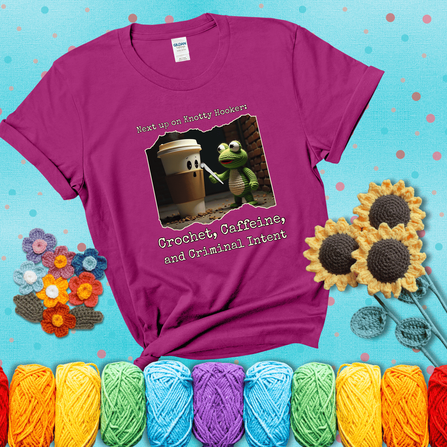 A crocheted frog holding a crochet hook confronts a surprised coffee cup in a dim alleyway with text: "Next up on Knotty Hooker: Crochet, Caffeine, and Criminal Intent," showing a magenta tee with a teal sunflower background