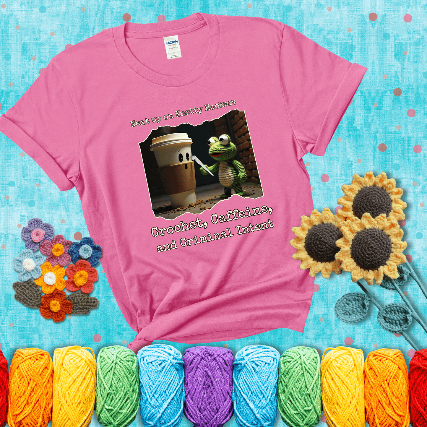 A crocheted frog holding a crochet hook confronts a surprised coffee cup in a dim alleyway with text: "Next up on Knotty Hooker: Crochet, Caffeine, and Criminal Intent," showing a pink tee with a teal sunflower background