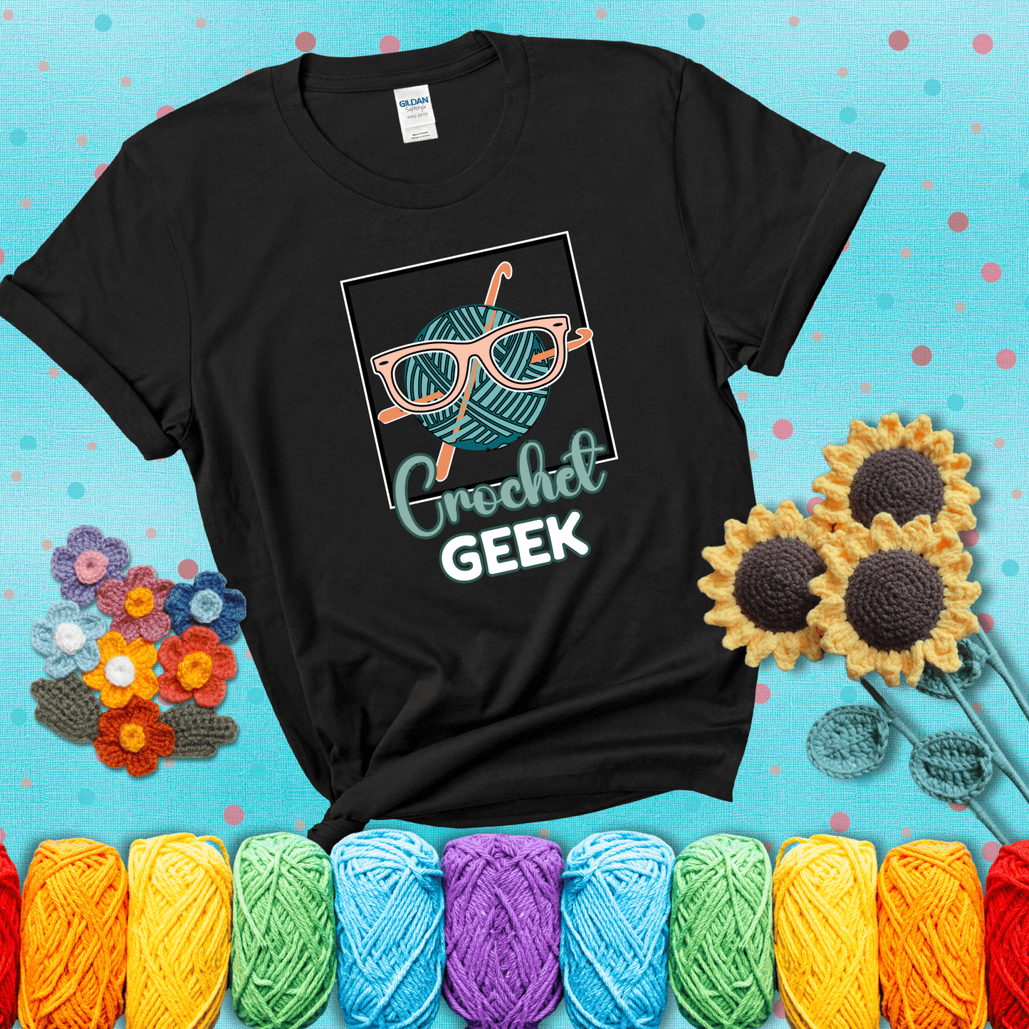 A teal yarn ball with crisscrossed hooks wears oversized nerdy glasses with the phrase “Crochet Geek” in bold, fun text below, showing a black tee with a teal sunflower background