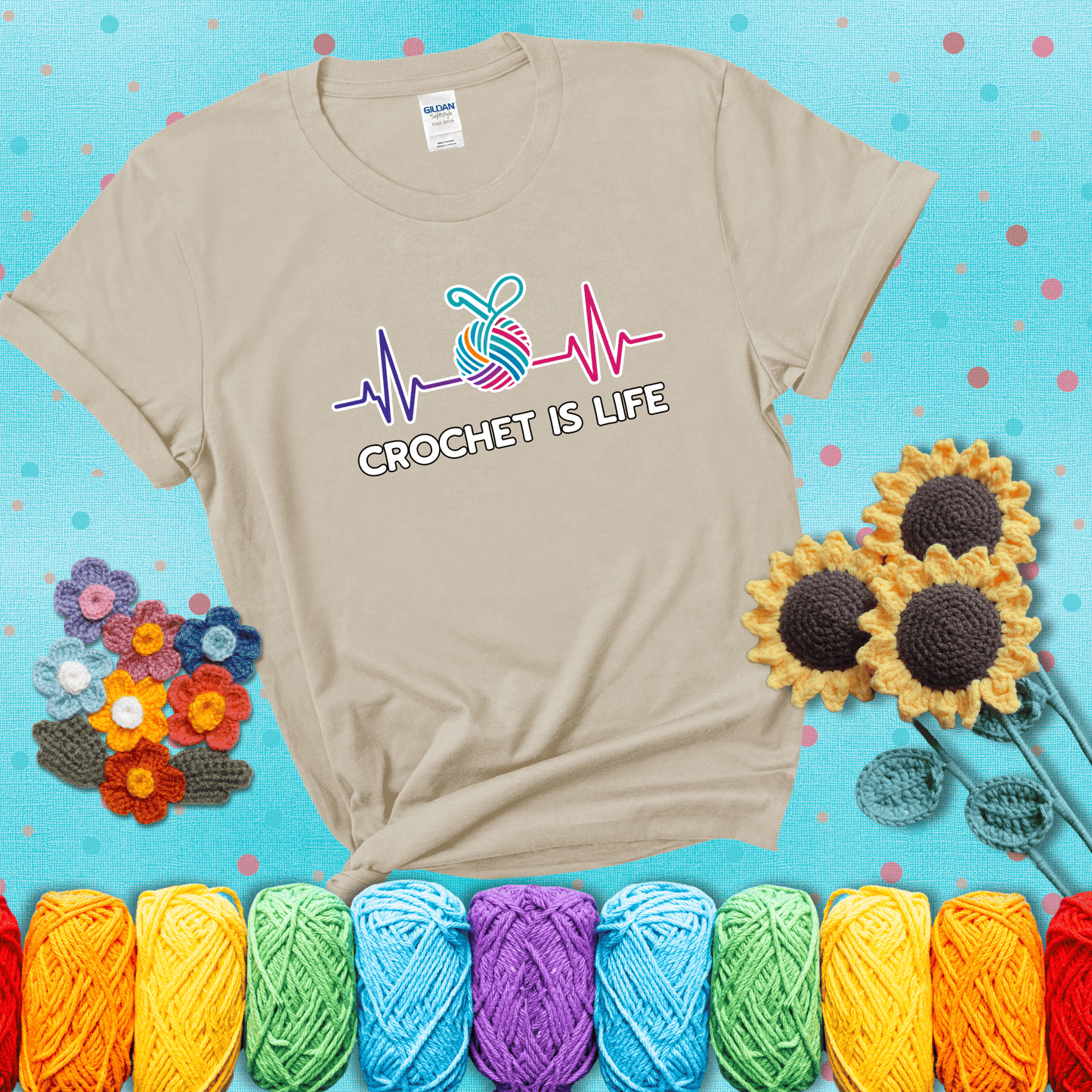 A heartbeat line with a colorful yarn ball and crochet hook in the center, with the words “Crochet is Life”, showing a beige tee with a teal sunflower background