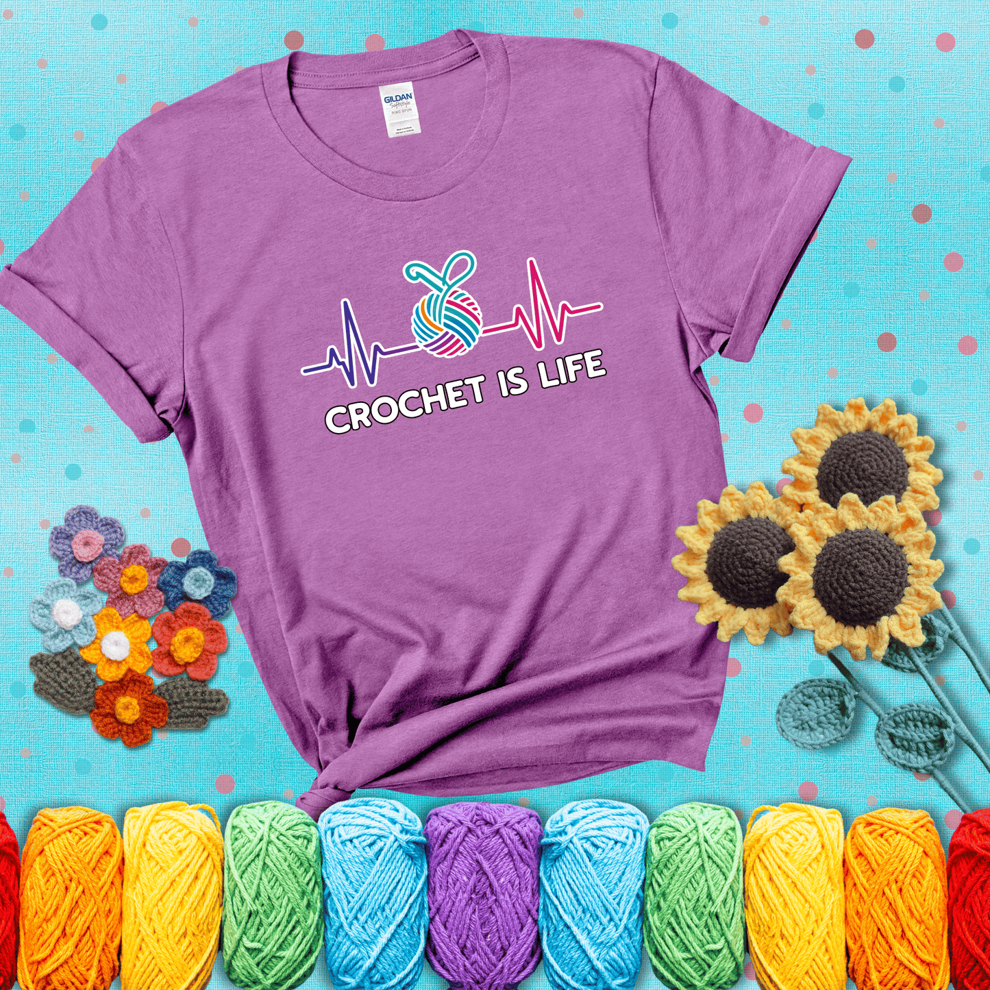 A heartbeat line with a colorful yarn ball and crochet hook in the center, with the words “Crochet is Life”, showing a light purple tee with a teal sunflower background