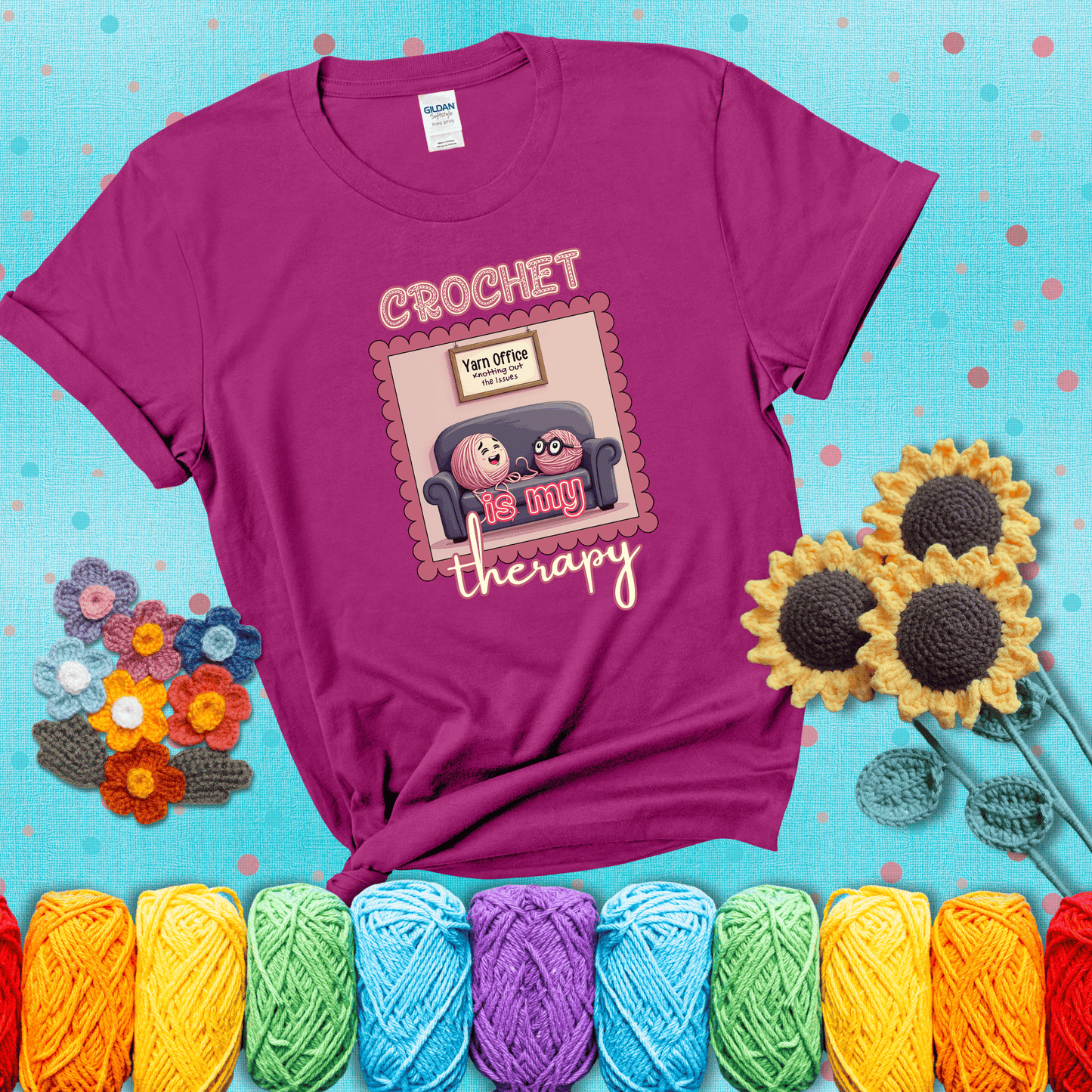 Simple text design with soothing yarn elements. Text reads: “Crochet is My Therapy.” A calming tee for fiber lovers who find healing in every stitch; showing a magenta tee with a teal sunflower background