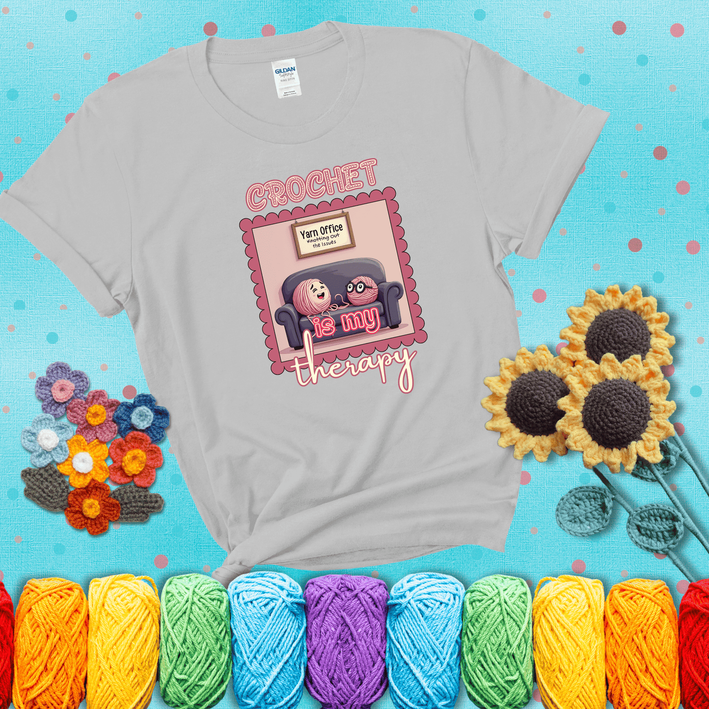 Simple text design with soothing yarn elements. Text reads: “Crochet is My Therapy.” A calming tee for fiber lovers who find healing in every stitch; showing a light grey tee with a teal sunflower background