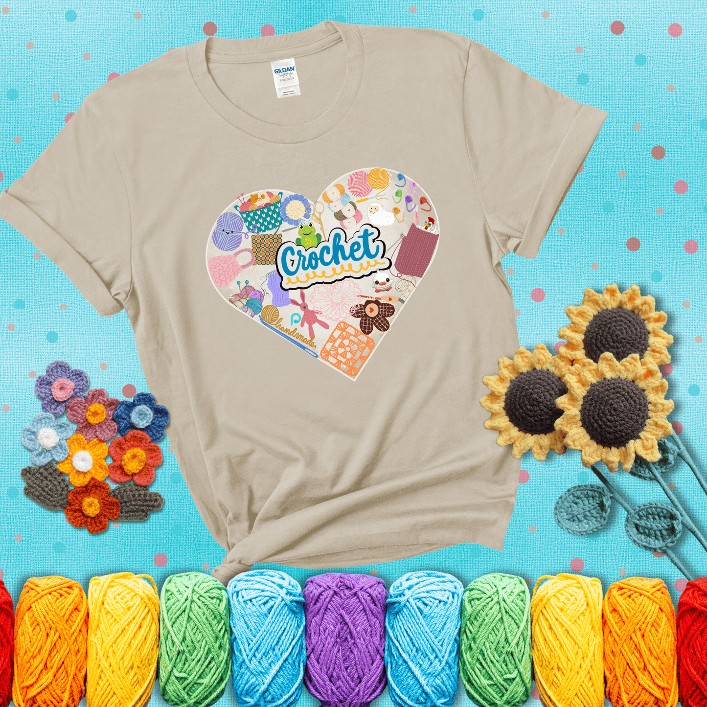 A heart filled with colorful crochet essentials including yarn, hooks, scissors, notions, and handmade items, with the word "Crochet" prominently in the center, showing a beige tee with a teal sunflower background