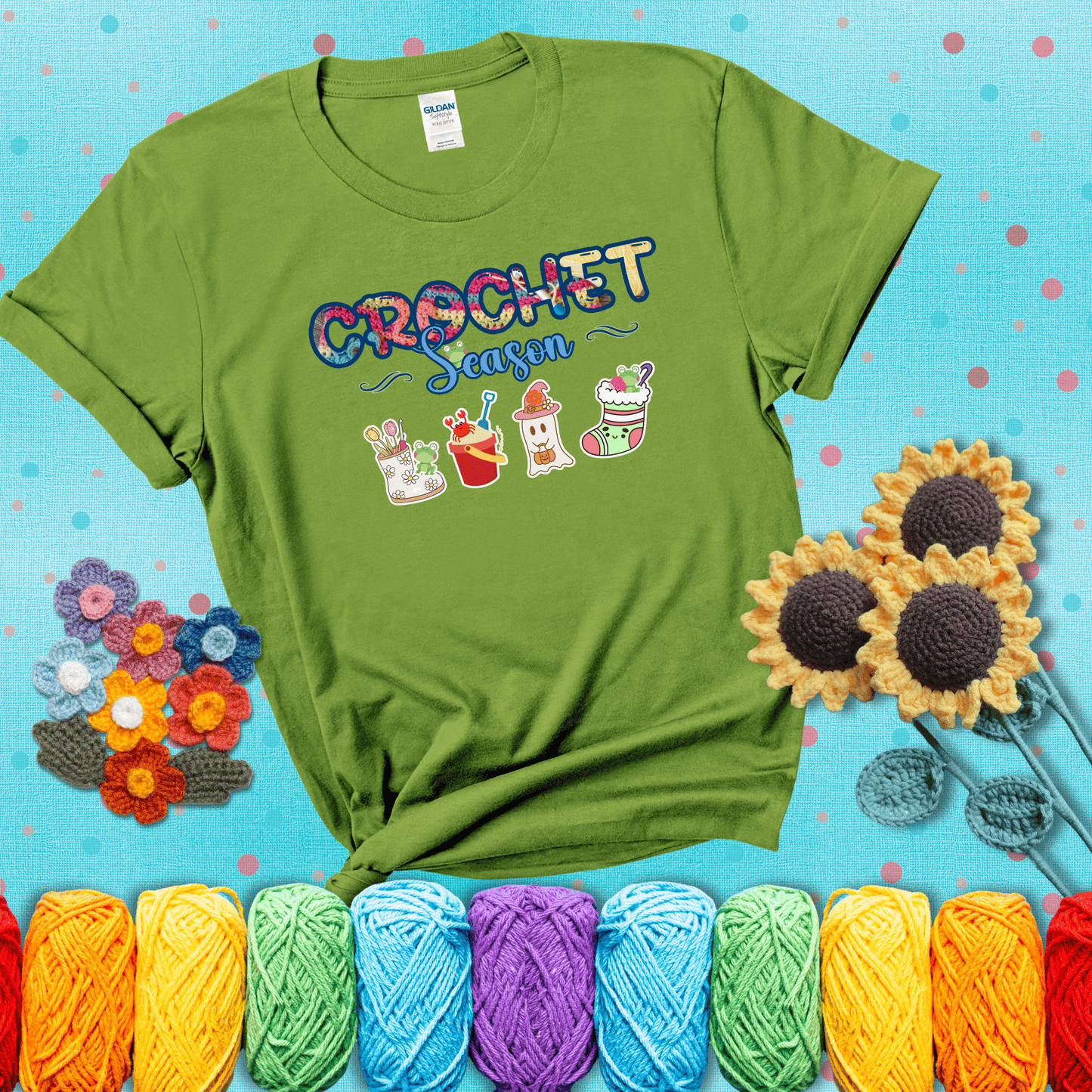 The words “Crochet Season” with cute seasonal icons below: a spring boot with hooks, summer bucket with crab, fall ghost with pumpkin hat, and winter stocking - all with tiny frogs; showing a bright green tee with a teal sunflower background