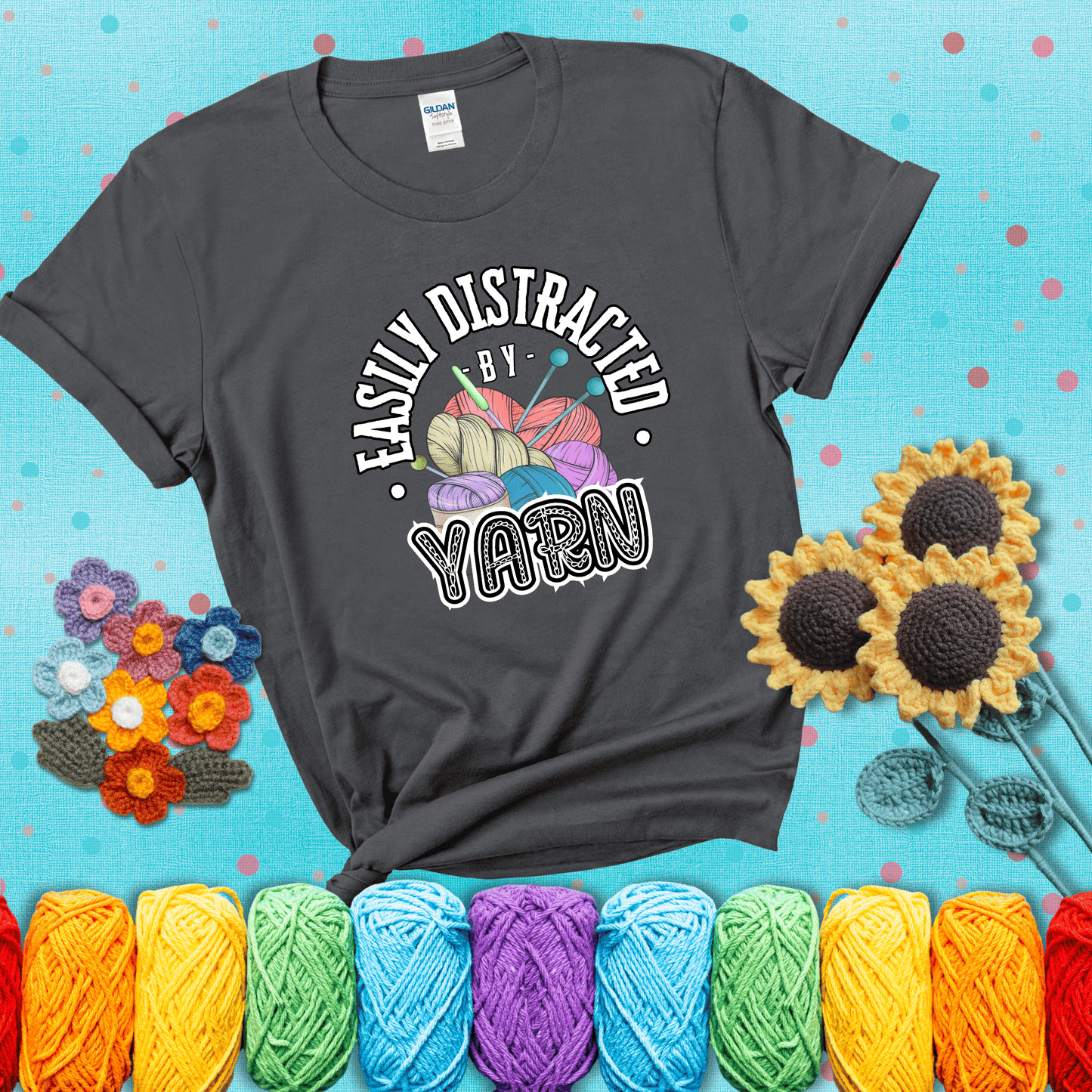 If yarn steals your focus every Design reads 'Easily Distracted By Yarn', perfect crochet gift for yarn lovers; showing a dark grey tee with a teal sunflower background