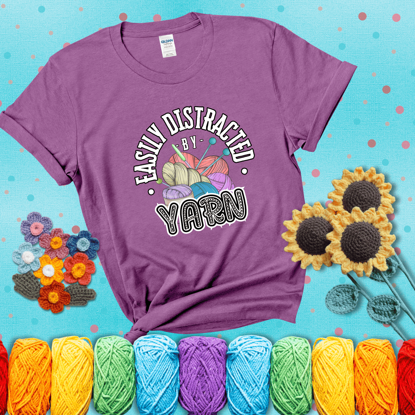 If yarn steals your focus every Design reads 'Easily Distracted By Yarn', perfect crochet gift for yarn lovers; showing a light purple tee with a teal sunflower background