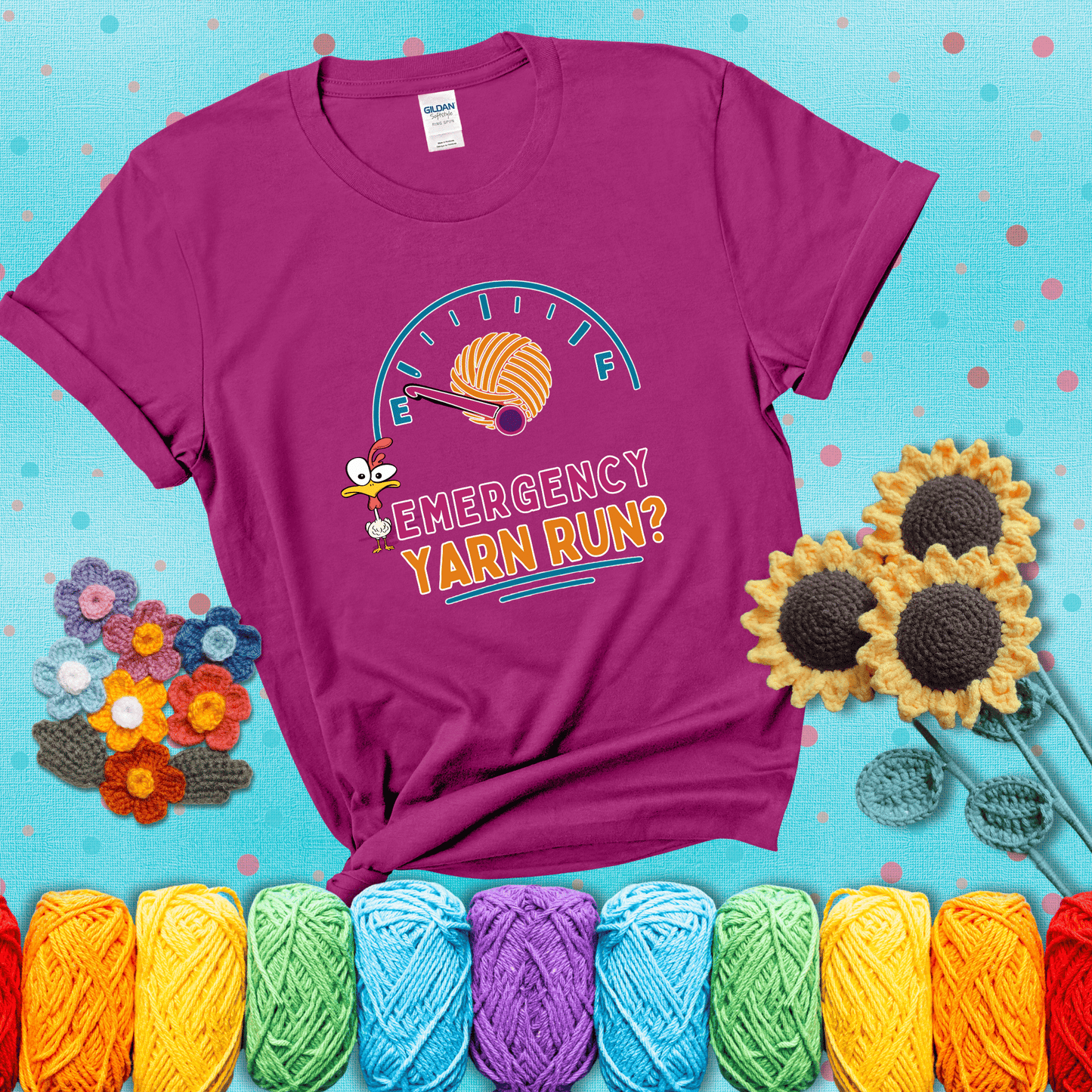 A fuel gauge with a ball of yarn as the needle pointing to empty, a frantic chicken, and the text “Emergency Yarn Run?” showing a magenta tee with a teal sunflower background