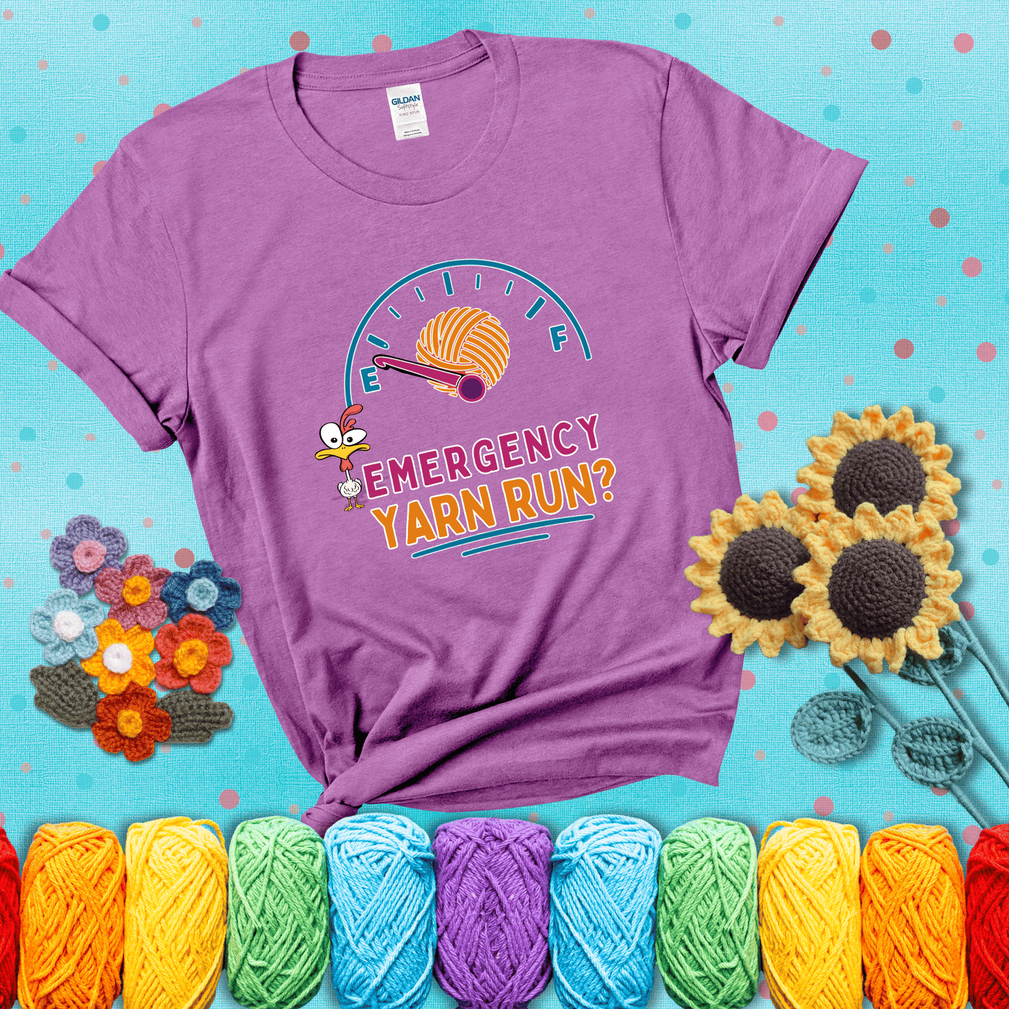 A fuel gauge with a ball of yarn as the needle pointing to empty, a frantic chicken, and the text “Emergency Yarn Run?” showing a light purple tee with a teal sunflower background