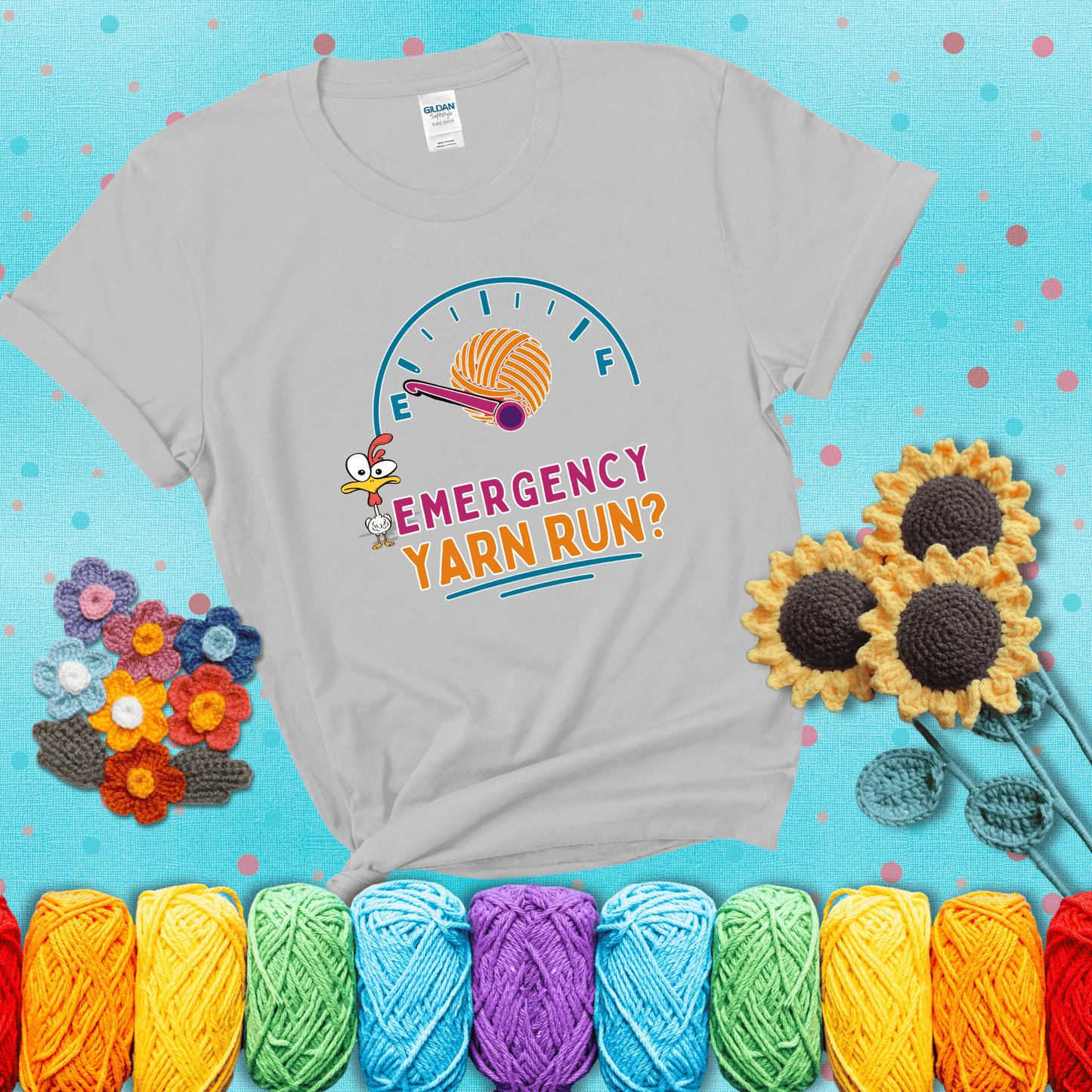 A fuel gauge with a ball of yarn as the needle pointing to empty, a frantic chicken, and the text “Emergency Yarn Run?” showing a light grey tee with a teal sunflower background