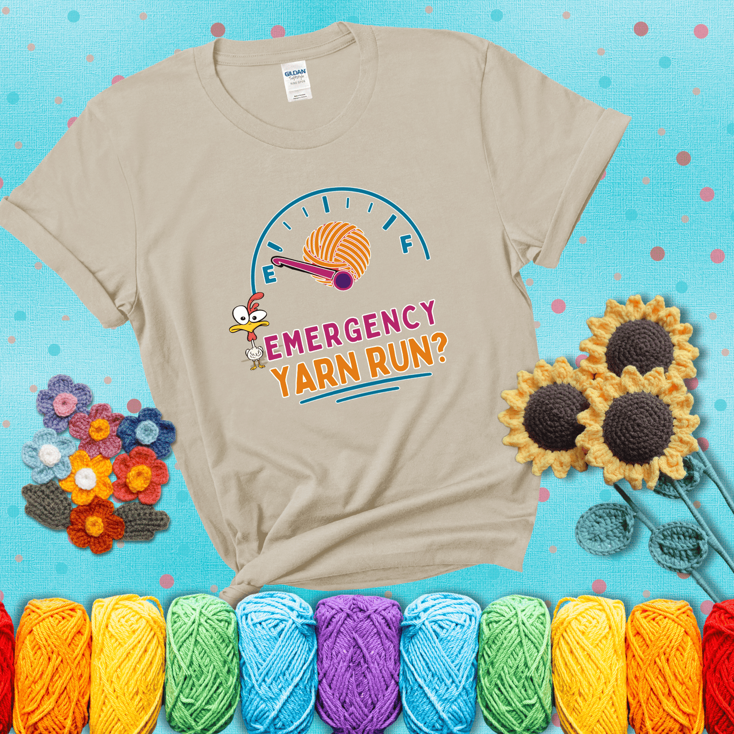 A fuel gauge with a ball of yarn as the needle pointing to empty, a frantic chicken, and the text “Emergency Yarn Run?” showing a beige tee with a teal sunflower background