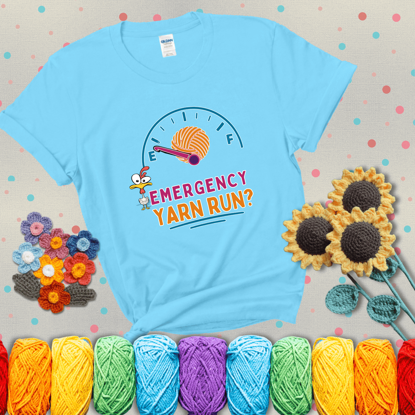 A fuel gauge with a ball of yarn as the needle pointing to empty, a frantic chicken, and the text “Emergency Yarn Run?” showing a light blue tee with grey sunflower background