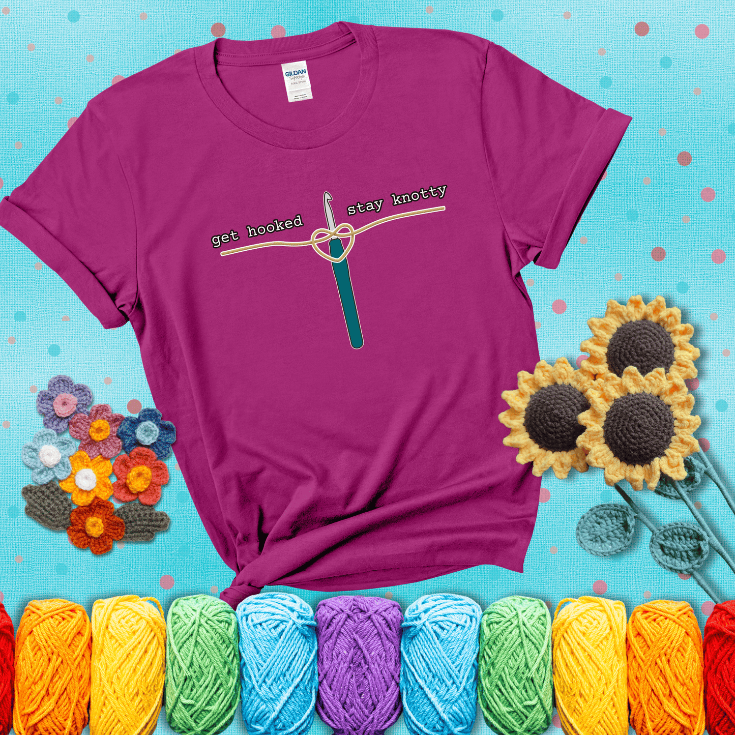 Hooked on yarn? Same Design reads 'Get Hooked, Stay Knotty' , perfect crochet gift for yarn lovers, showing a magenta tee with a teal sunflower background