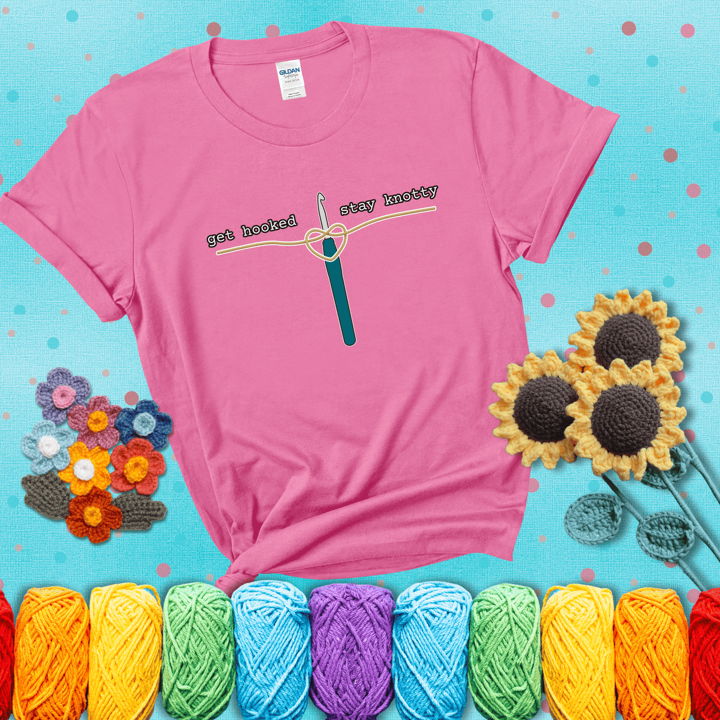 Hooked on yarn? Same Design reads 'Get Hooked, Stay Knotty' , perfect crochet gift for yarn lovers, showing a pink tee with a teal sunflower background