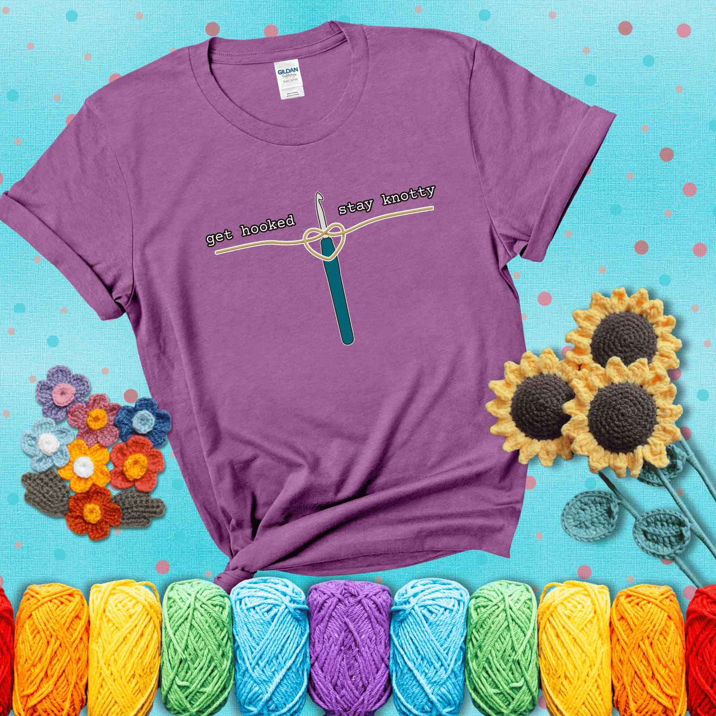 Hooked on yarn? Same Design reads 'Get Hooked, Stay Knotty' , perfect crochet gift for yarn lovers, showing a light purple tee with a teal sunflower background