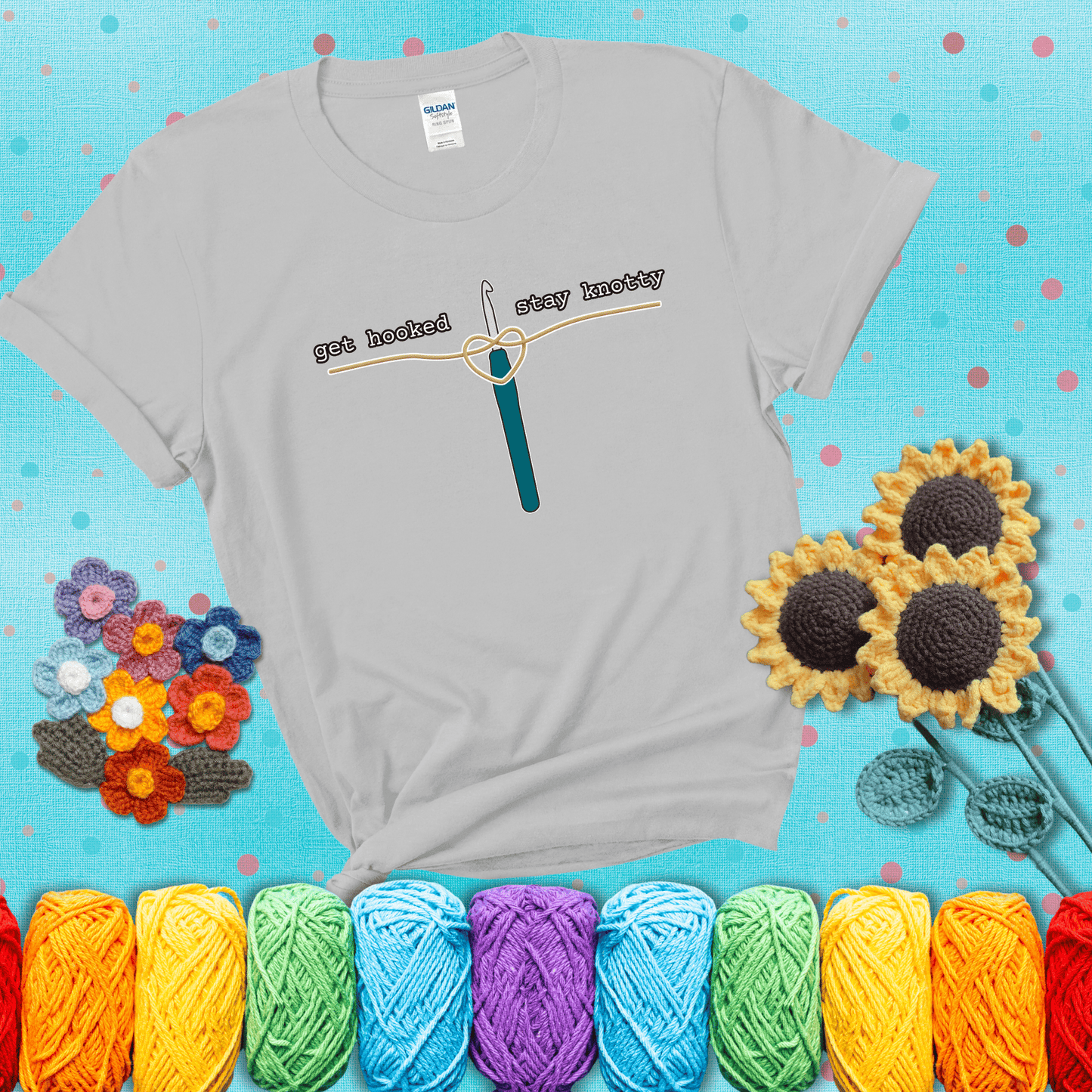 Hooked on yarn? Same Design reads 'Get Hooked, Stay Knotty' , perfect crochet gift for yarn lovers, showing a light grey tee with a teal sunflower background