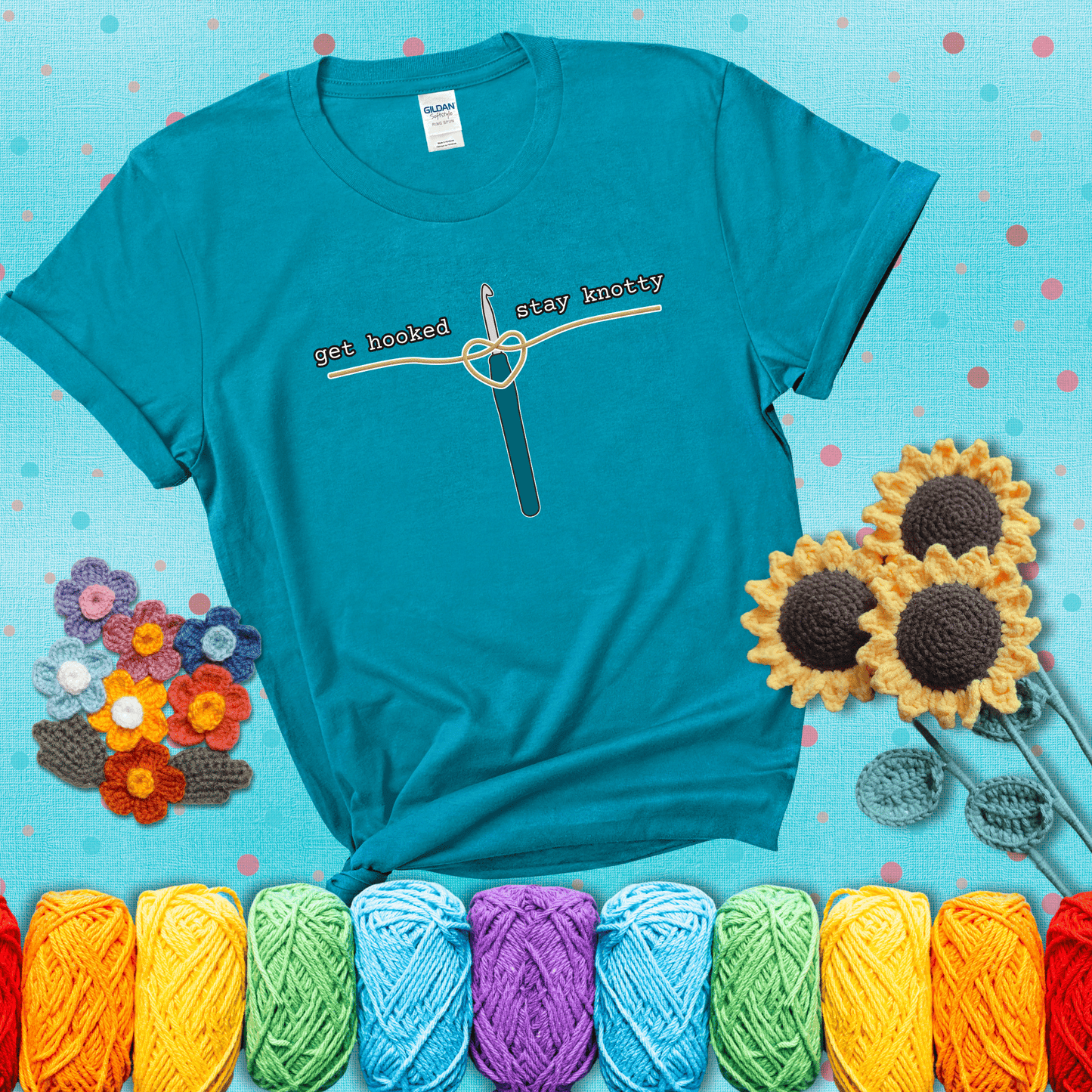 Hooked on yarn? Same Design reads 'Get Hooked, Stay Knotty' , perfect crochet gift for yarn lovers, showing a blue-green tee with a teal sunflower background