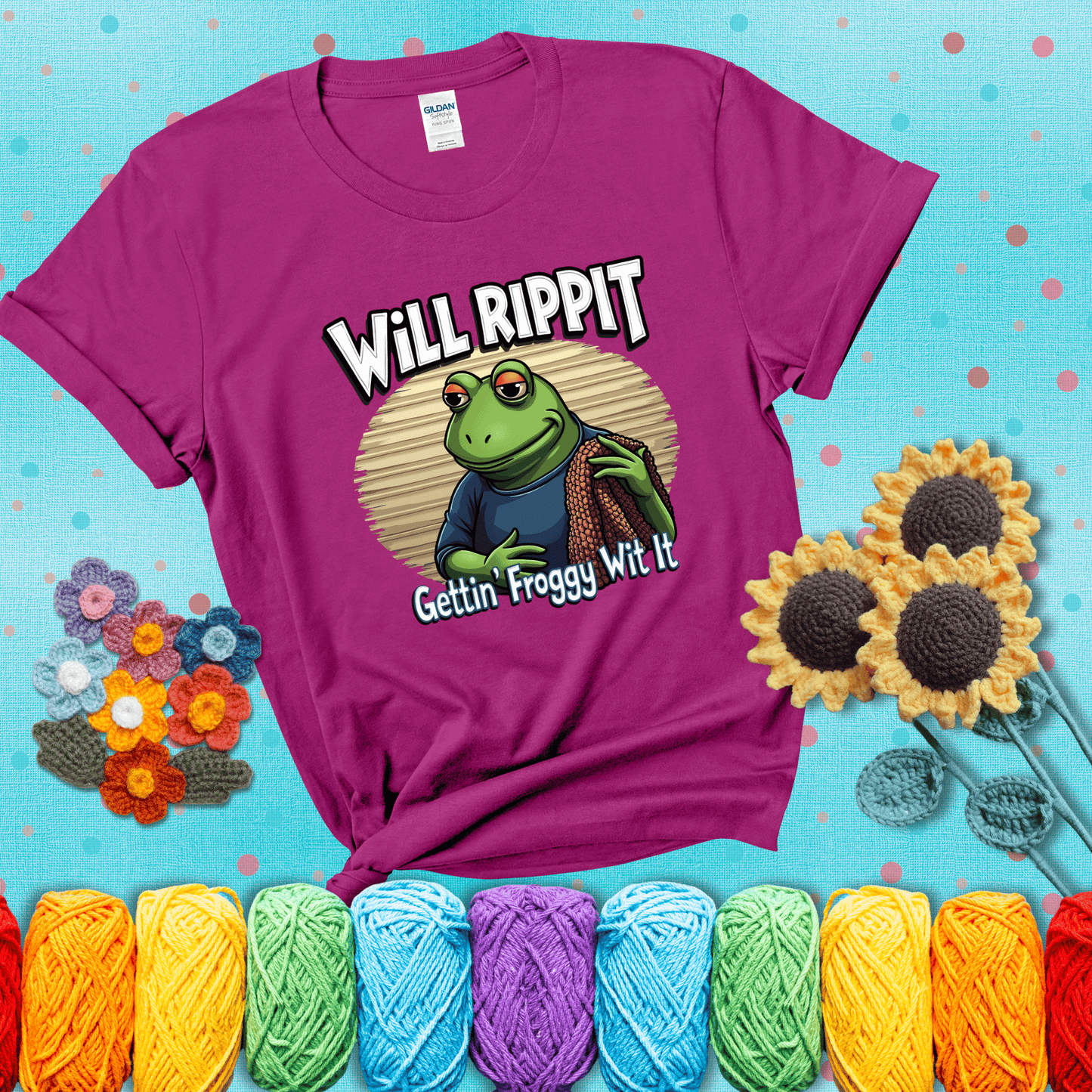 Cool frog with sunglasses, surrounded by yarn and hooks. Text reads: “Gettin’ Froggy Wit It.” A hip and humorous crochet tee for yarn lovers with rhythm, showing a magenta tee with a teal sunflower background
