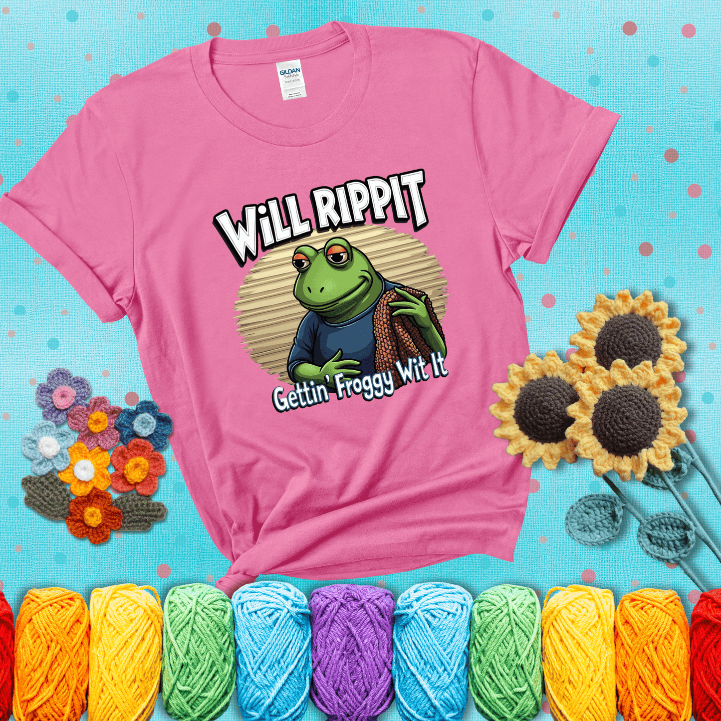 Cool frog with sunglasses, surrounded by yarn and hooks. Text reads: “Gettin’ Froggy Wit It.” A hip and humorous crochet tee for yarn lovers with rhythm, showing a pink tee with a teal sunflower background